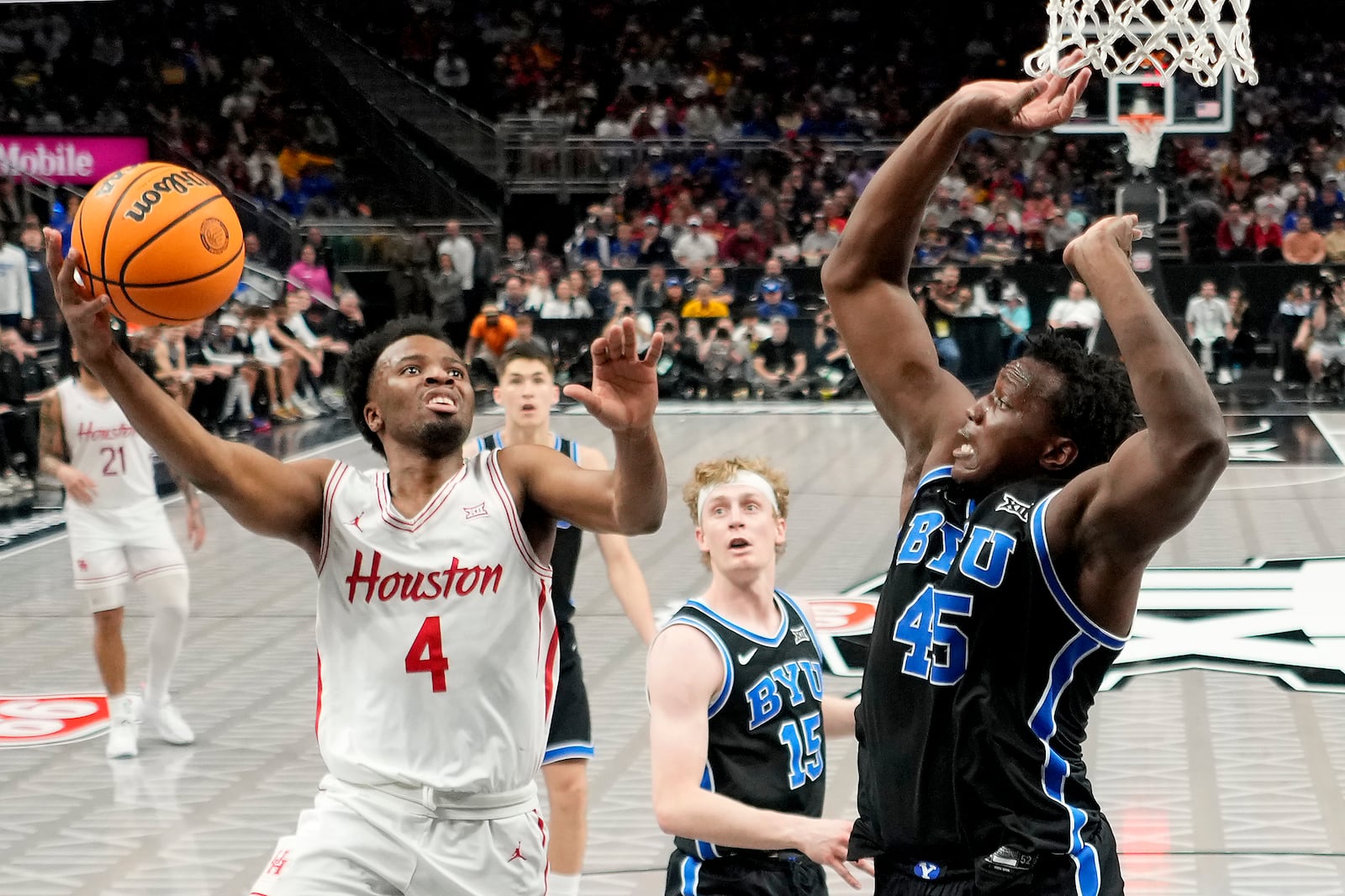 Houston guard L.J. Cryer (4) shoots under pressure from Brigham Young center Fousseyni Traore (45) during the first half of a semifinal NCAA college basketball game in the Big 12 men's tournament Friday, March 14, 2025, in Kansas City, Mo. (AP Photo/Charlie Riedel)