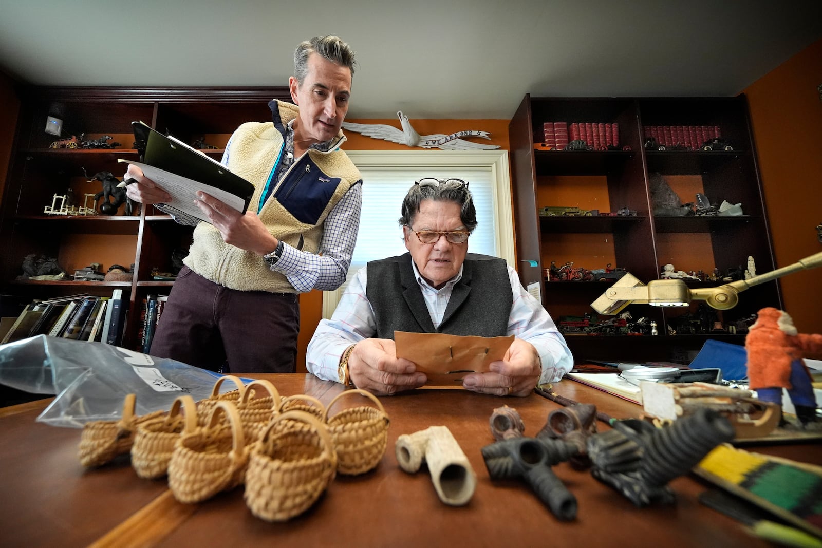 Appraiser Kaja Veilleux, seated, examines a document while associate appraiser Darrin Guitreau takes notes at Thomaston Place Auction Galleries, Tuesday, Nov. 19, 2024, in Thomaston, Maine. (AP Photo/Robert F. Bukaty)