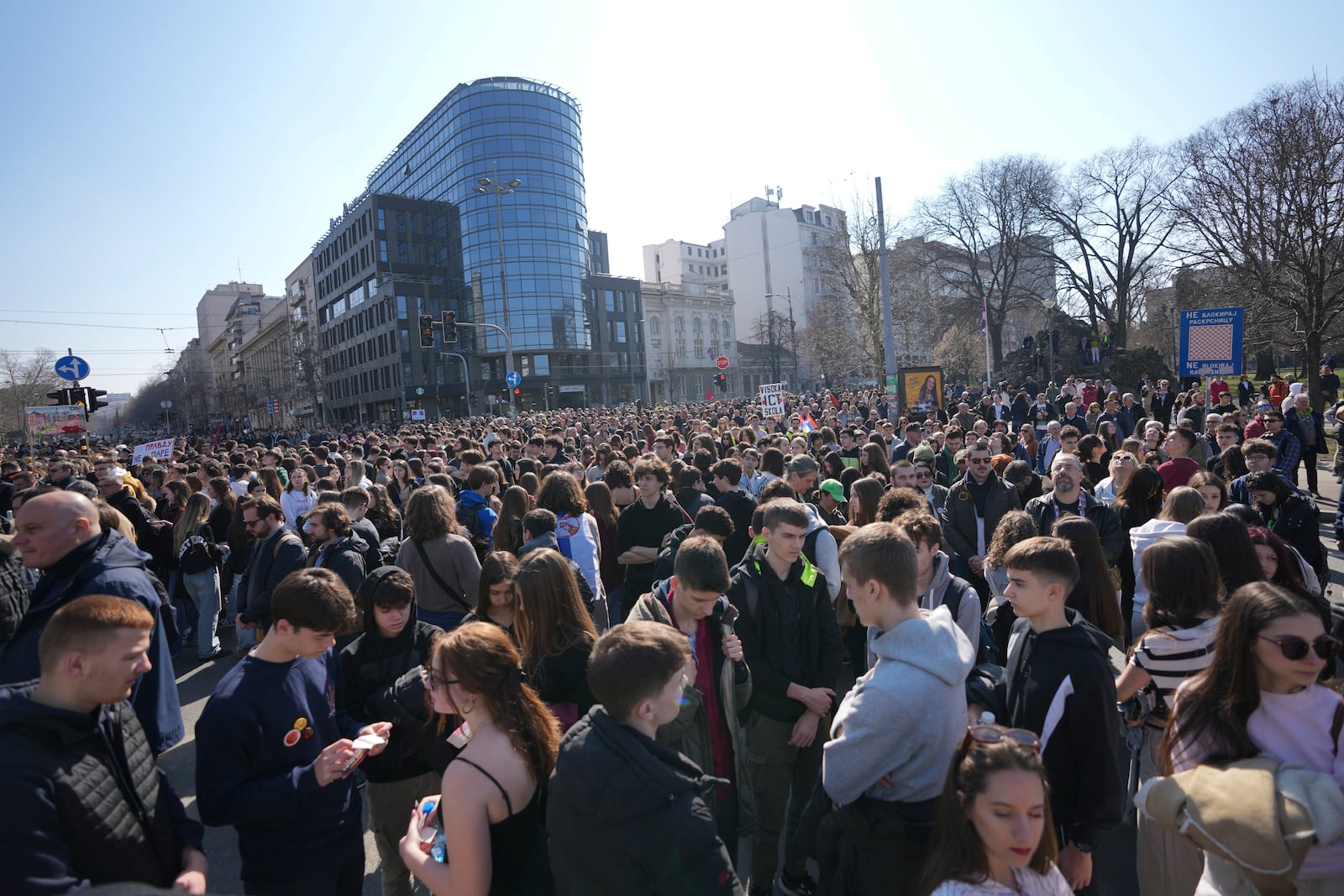 People stand in silence to commemorate the 15 victims killed after a railway concrete canopy fell in November 2024, during a Serbia's parliament session in Belgrade, Serbia, Tuesday, March 4, 2025. (AP Photo/Darko Vojinovic)