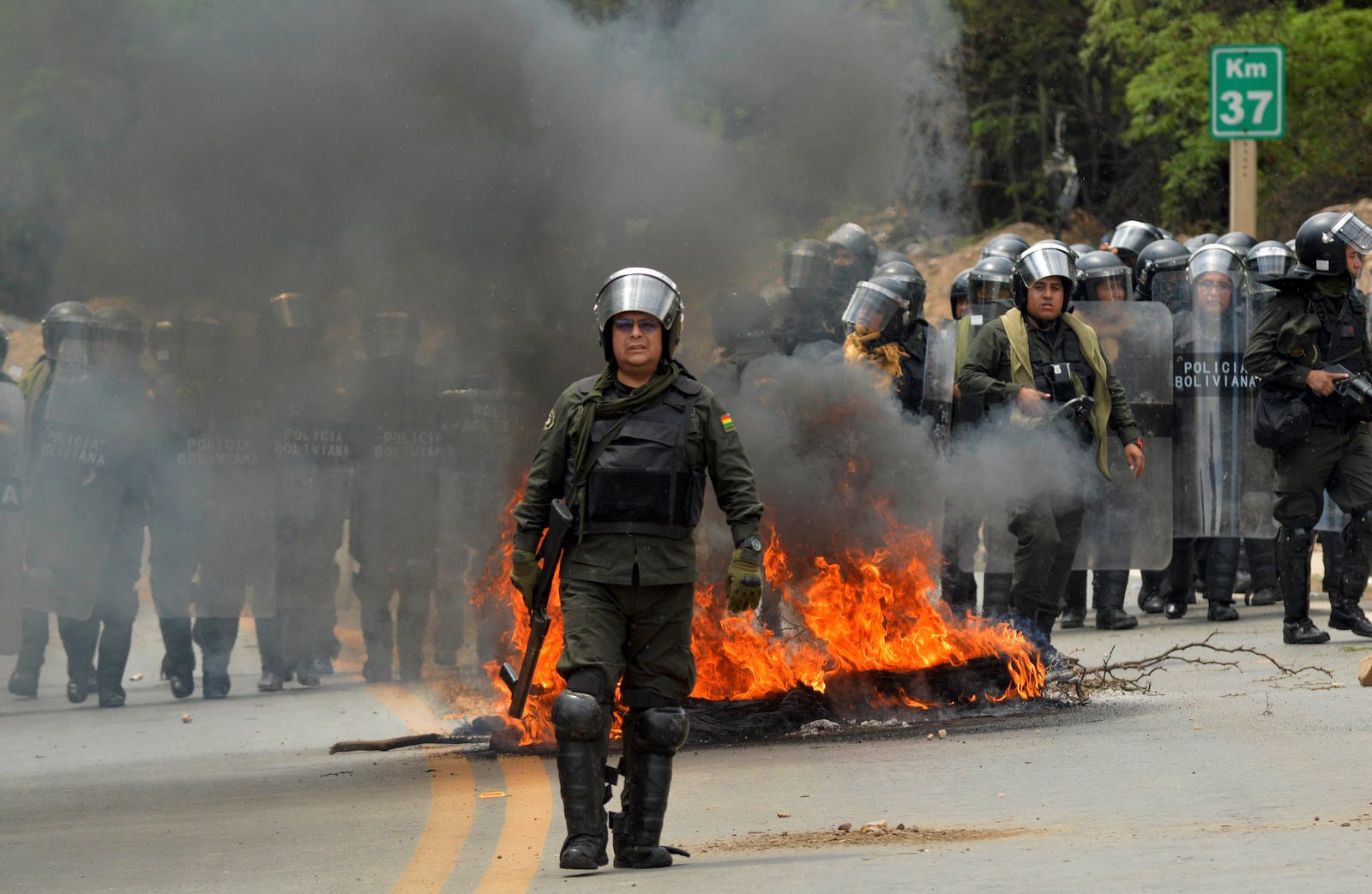 Riot police clash with supporters of former Bolivian President Evo Morales during a roadblock to pressure against him being prosecuted over allegations of minor abuse, near Cochabamba, Bolivia, Friday, Oct. 25, 2024. (AP Photo/Daniel Cartagena)