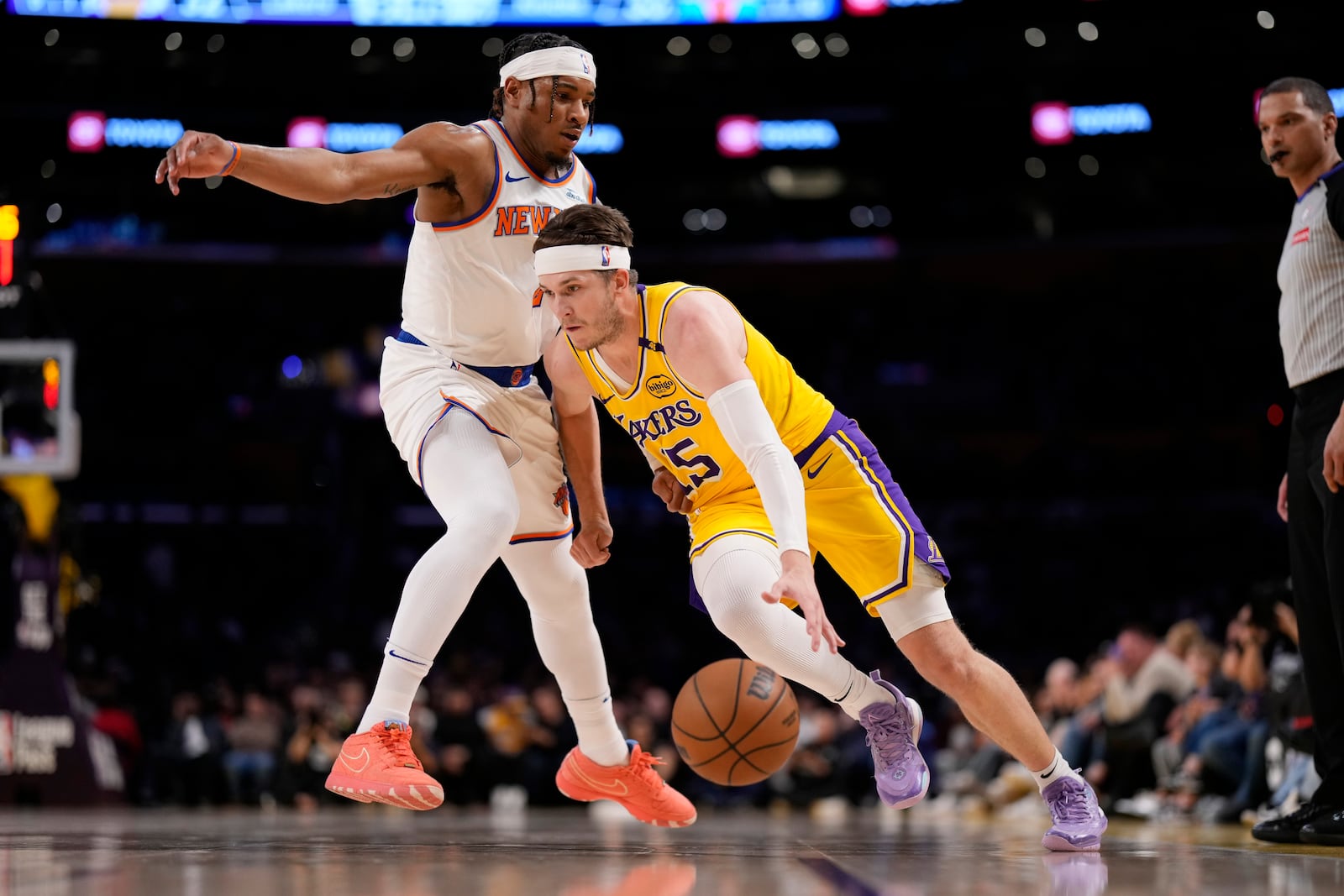 Los Angeles Lakers guard Austin Reaves, right, drives past New York Knicks guard Miles McBride during the first half of an NBA basketball game Thursday, March 6, 2025, in Los Angeles. (AP Photo/Mark J. Terrill)