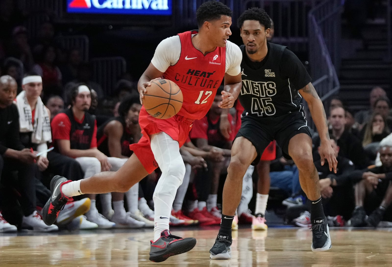 Miami Heat guard Dru Smith (12) dribbles as Brooklyn Nets guard Keon Johnson (45) defends during the first half of an NBA basketball game, Monday, Dec. 23, 2024, in Miami. (AP Photo/Lynne Sladky)