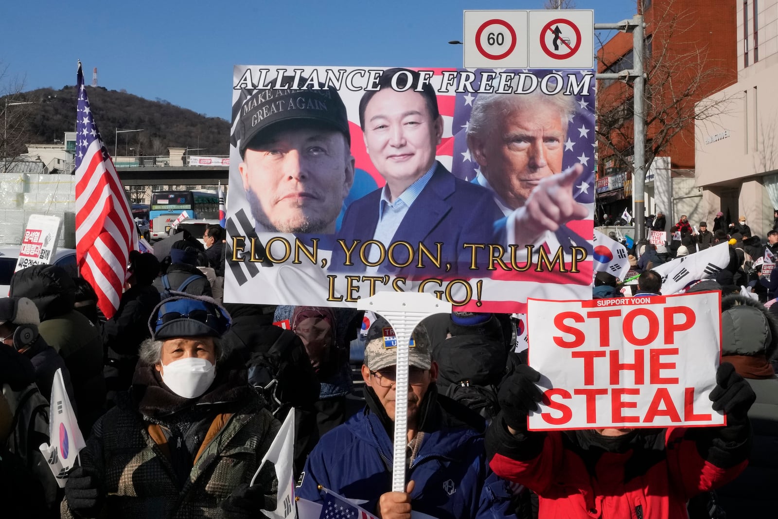 Supporters of impeached South Korean President Yoon Suk Yeol attend with a banner showing portraits of him, center, US President-elect Donald Trump and Tesla and SpaceX CEO Elon Musk, left, during a rally to oppose his impeachment near the presidential residence in Seoul, South Korea, Friday, Jan. 10, 2025. (AP Photo/Ahn Young-joon)