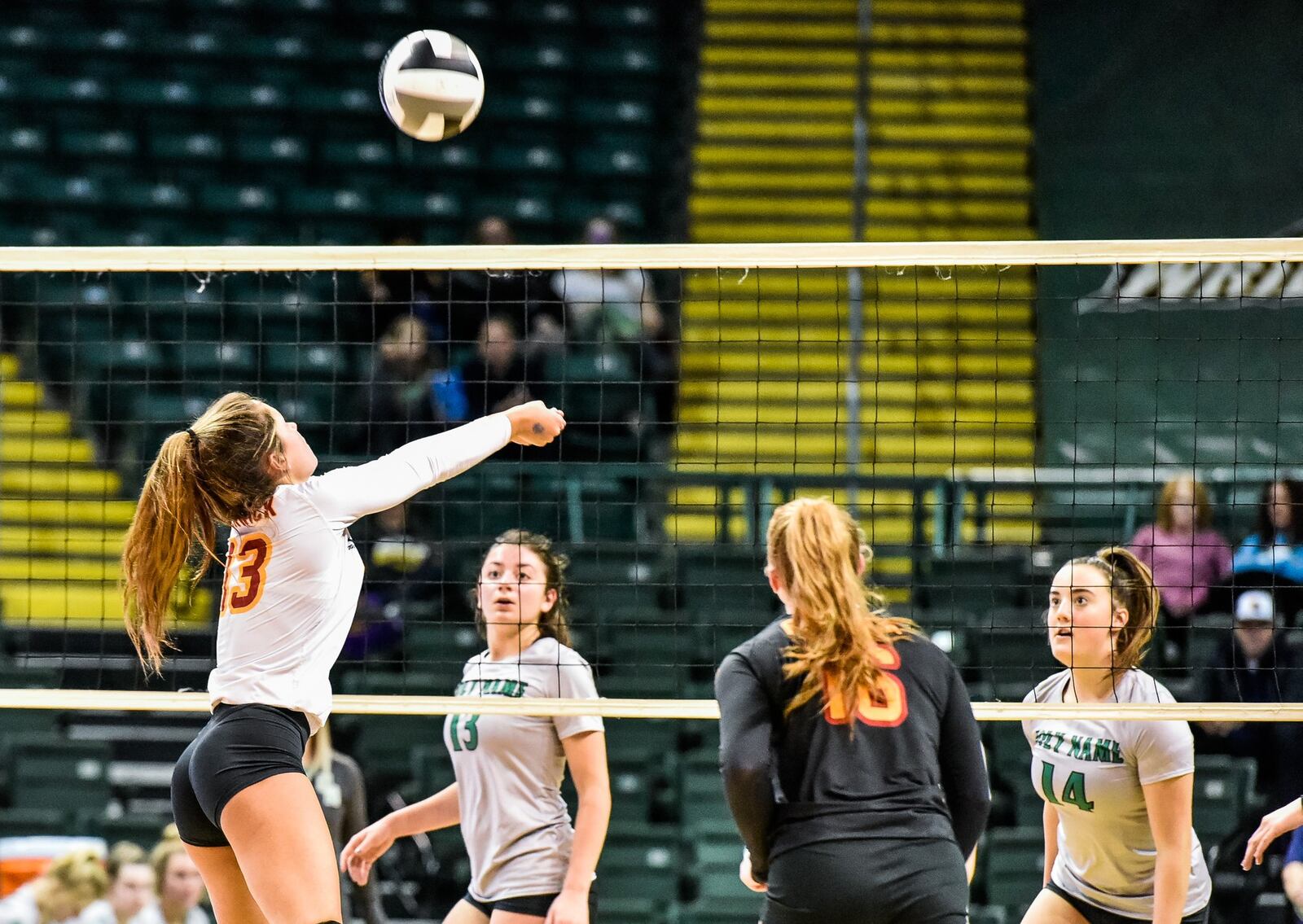 Fenwick’s Bella DeSalvo connects with the ball as teammate Grace Maziar (16) watches during Friday’s Division II state volleyball semifinal against Parma Heights Holy Name at Wright State University’s Nutter Center. Holy Name’s Abriana Marchetta (13) and Mary Margaret Adams (14) are on defense. NICK GRAHAM/STAFF