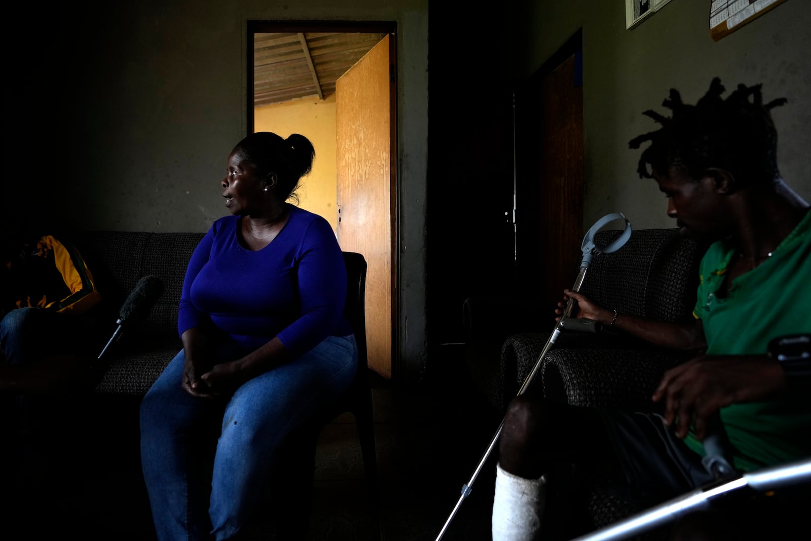 Mmastona Mbizana, left, a community member of Khumo township, speaks to The Associated Press while her son, Lucky Mbizana, watches in Stilfontein, South Africa, Wednesday, Jan. 15, 2025. (AP Photo/Themba Hadebe)