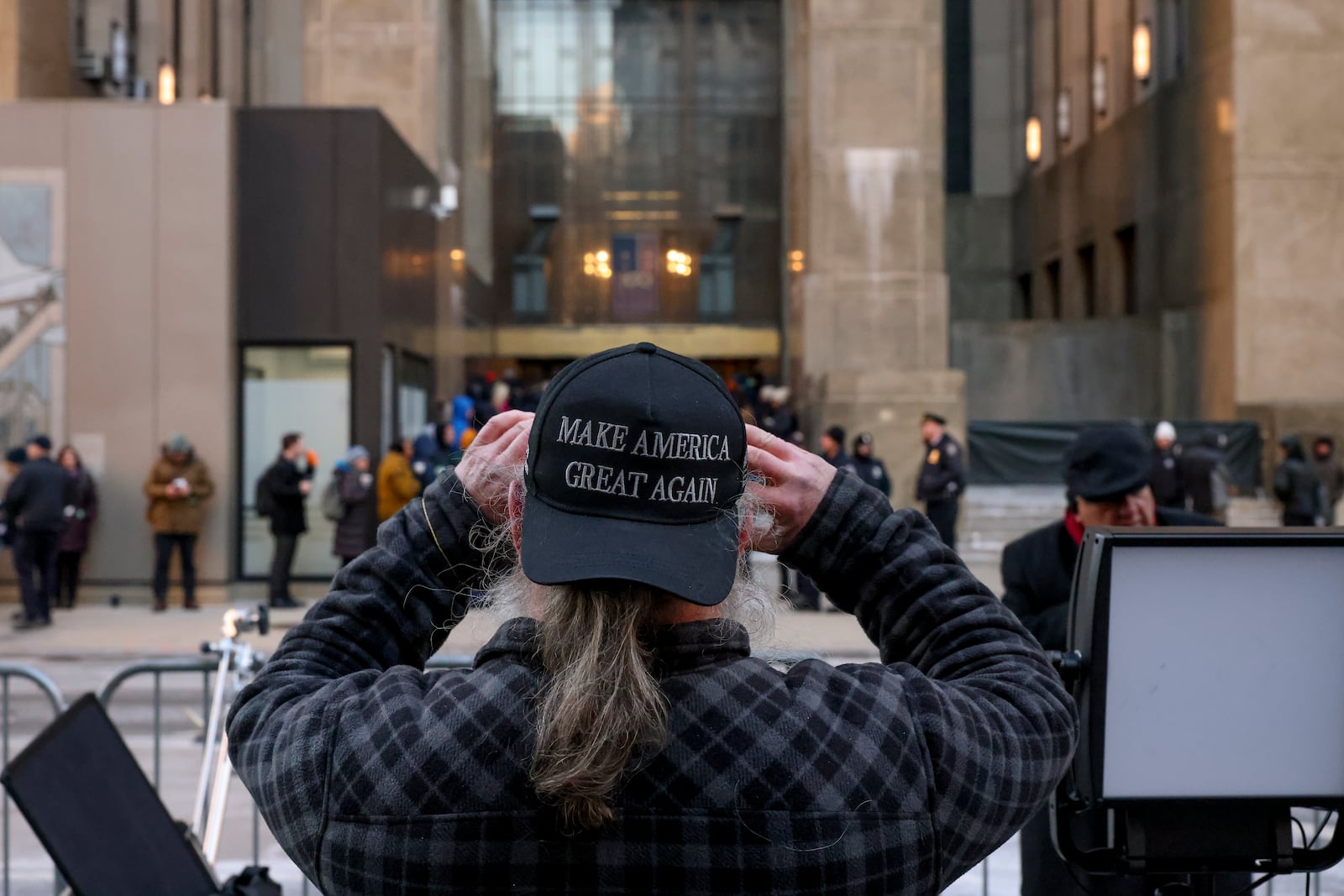 A supporter for President-elect Donald Trump takes a photo of the Manhattan criminal courthouse before the start of the sentencing in Trump's hush money case, Friday, Jan. 10, 2025, in New York. (AP Photo/Yuki Iwamura)