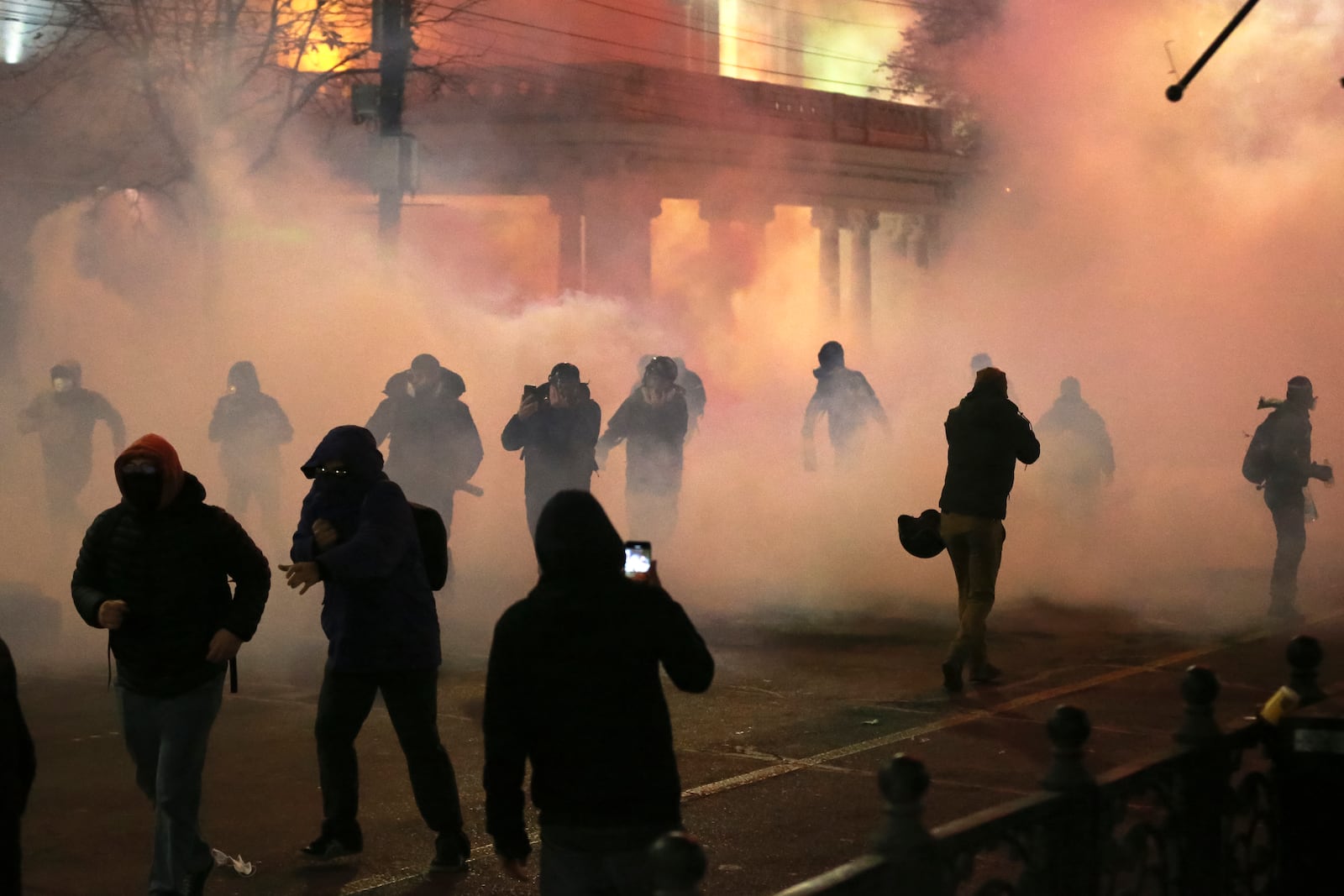 Demonstrators walk trough a cloud of tear gas to continue protests against the government's decision to suspend negotiations on joining the European Union in Tbilisi, Georgia, early Tuesday, Dec. 3, 2024. (AP Photo/Zurab Tsertsvadze)