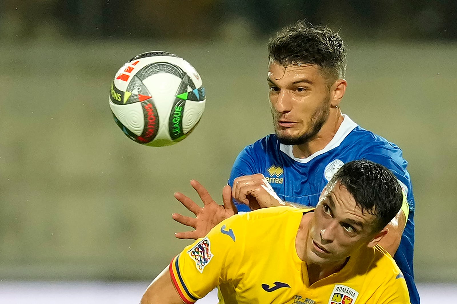 Cyprus' Kostakis Artymatas, rear, and Romania's Nicolae Stanciu fight for the ball during the Nations League soccer match between Cyprus and the Romania at the AEK Arena in Larnaca, Cyprus, Saturday, Oct. 12, 2024. (AP Photo/Petros Karadjias)