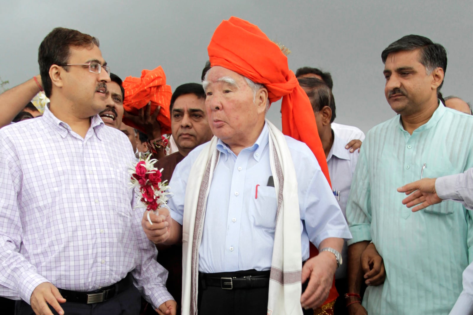 FILE - Suzuki Motor Corp. Chairman and Chief Executive Osamu Suzuki, center, receives a traditional welcome during his visit to the proposed site for Maruti Suzuki India Ltd's (MSIL) manufacturing facility at Hansalpur near Mehsana, about 110 kilometers (70 miles) north of Ahmadabad, India, Aug. 25, 2012. (AP Photo/AJit Solanki, File)