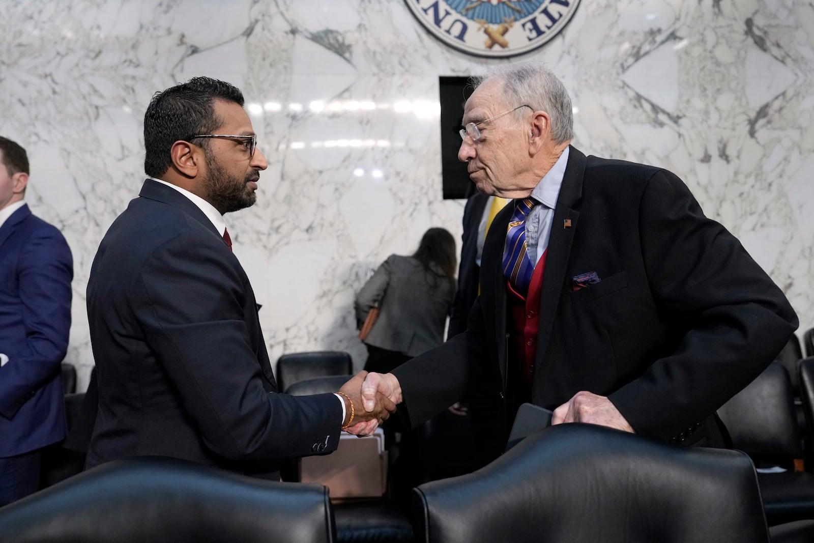 Kash Patel, President Donald Trump's choice to be director of the FBI, left, shakes the hand of Sen. Chuck Grassley, R-Iowa, as he departs following a confirmation hearing before the Senate Judiciary Committee at the Capitol in Washington, Thursday, Jan. 30, 2025. (AP Photo/Ben Curtis)