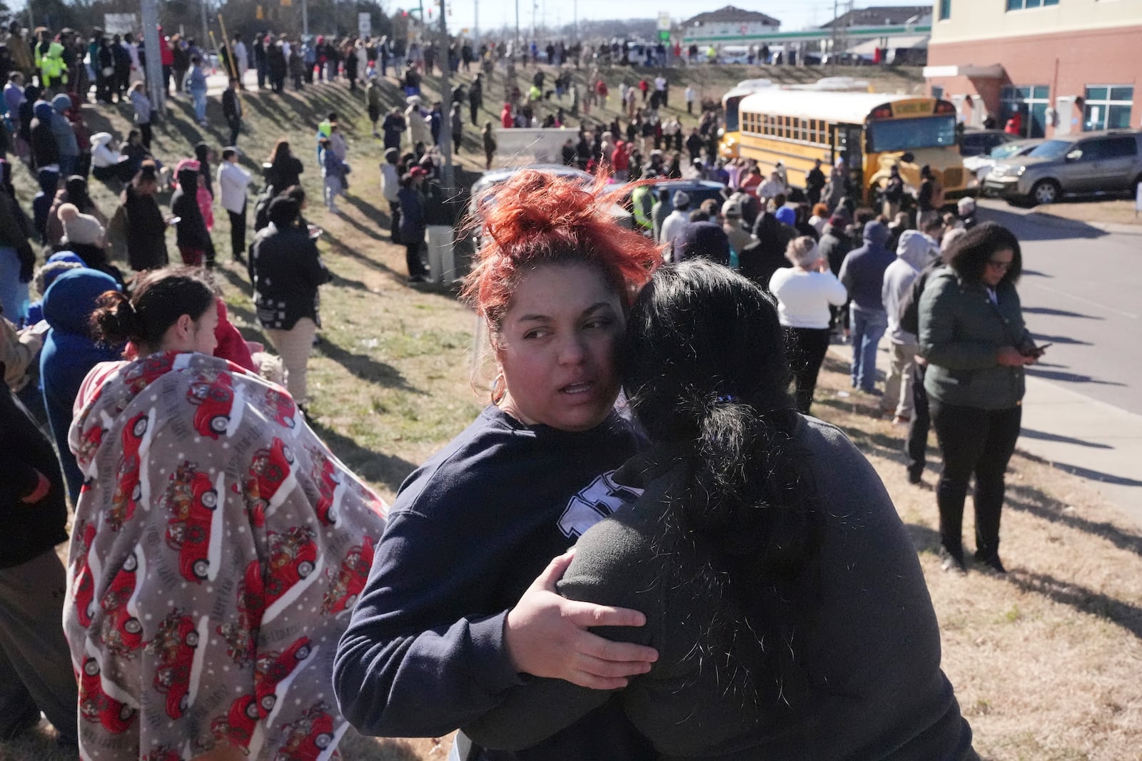 Families wait as school buses arrive at a unification site following a shooting at the Antioch High School in Nashville, Tenn., Wednesday, Jan. 22, 2025. (AP Photo/George Walker IV)