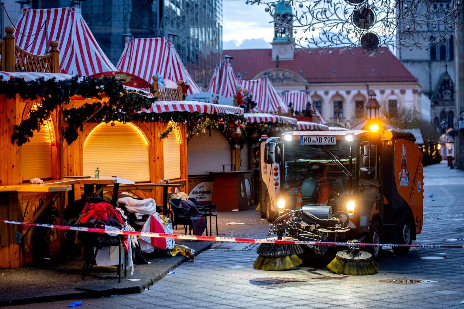 Public workers clean the Christmas Market, where a car drove into a crowd on Friday evening, in Magdeburg, Germany, is empty on Sunday morning , Dec. 22, 2024. (AP Photo/Michael Probst)