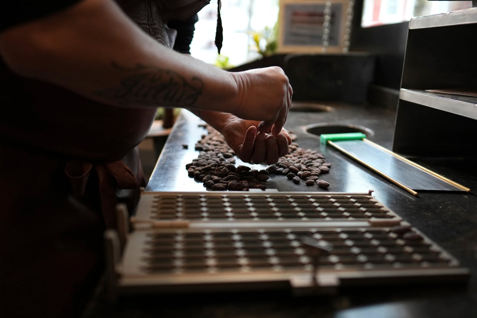 Artisan chocolatier Dominique Persoone sorts through cocoa beans in his workshop at The Chocolate Line in Bruges, Belgium, Thursday, Feb. 6, 2025. (AP Photo/Virginia Mayo)