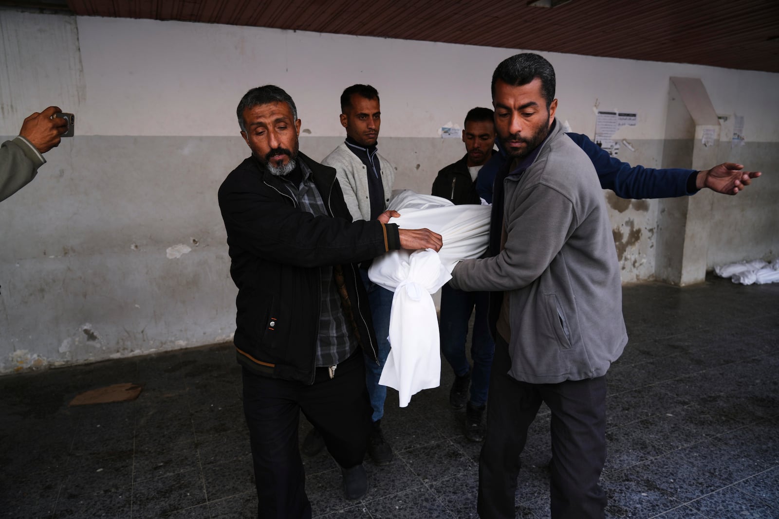 Mourners carry the bodies of Al-Mashharawi family members, who were killed in an Israeli airstrike that hit their home, at Al-Ahli Hospital in Gaza City on Saturday, March 22, 2025. (AP Photo/Jehad Alshrafi)