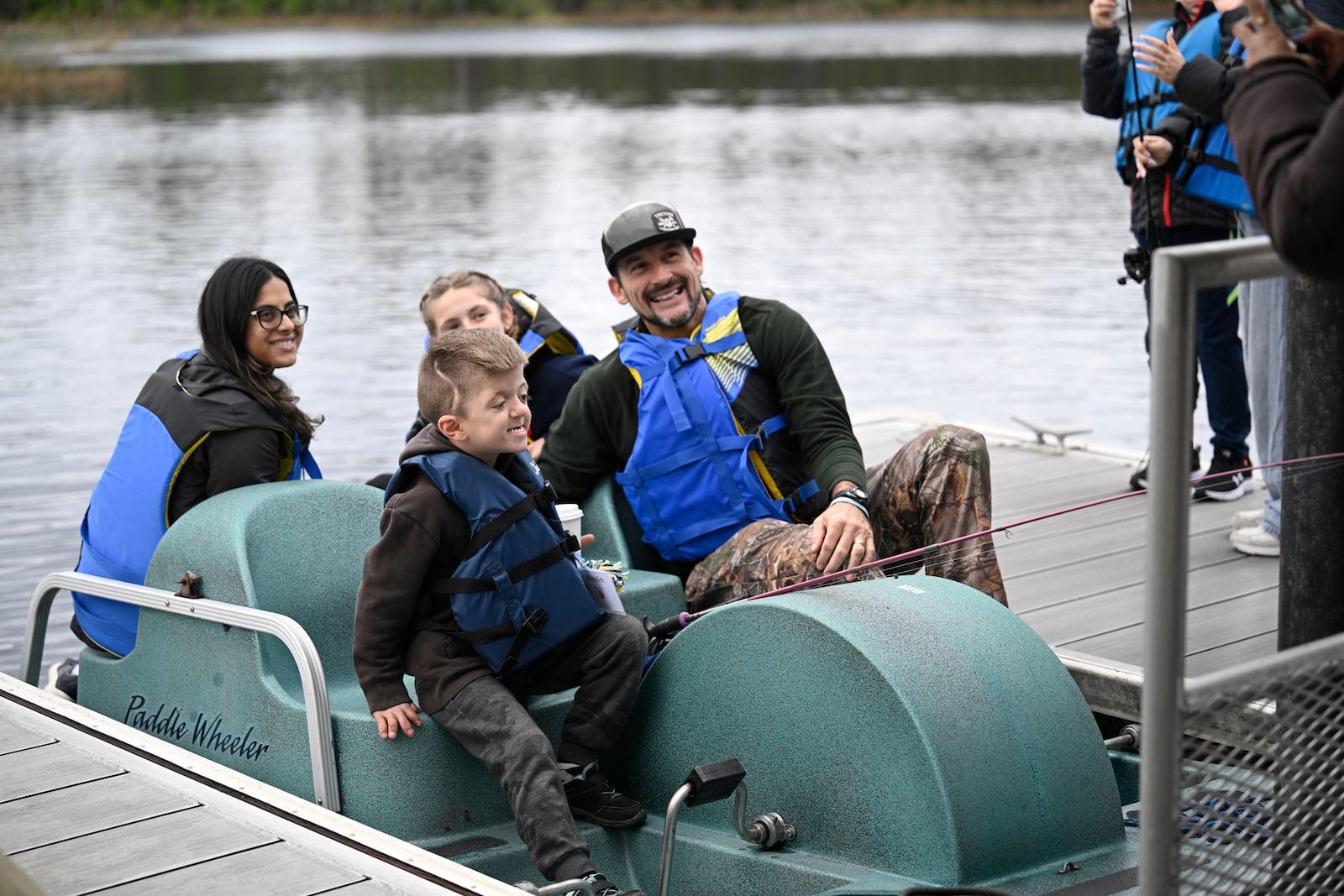 Children prepare to ride a paddle boat with volunteer counselors on Lake Palmer at Camp Boggy Creek, where children with serious illnesses and their families are provided with a free camp experience, Saturday, Jan. 11, 2025, in Eustis, Fla. (AP Photo/Phelan M. Ebenhack)