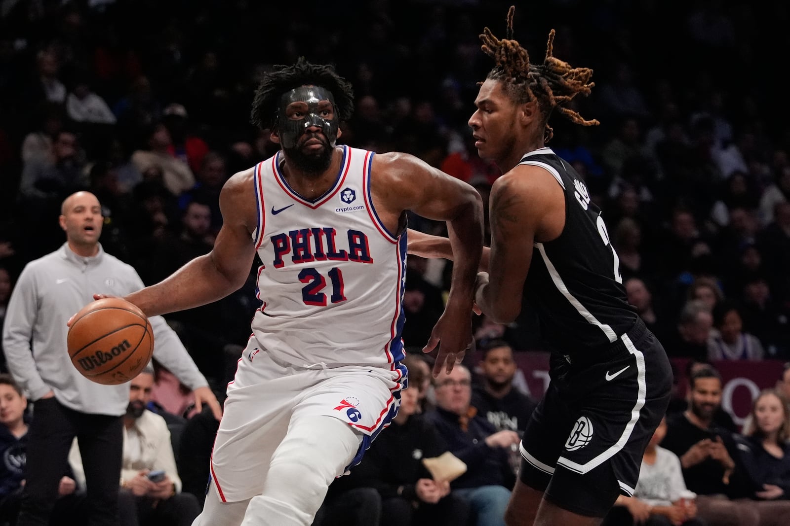 Philadelphia 76ers' Joel Embiid (21) drives past Brooklyn Nets' Jalen Wilson (22) during the second half of an NBA basketball game Saturday, Jan. 4, 2025, in New York. (AP Photo/Frank Franklin II)