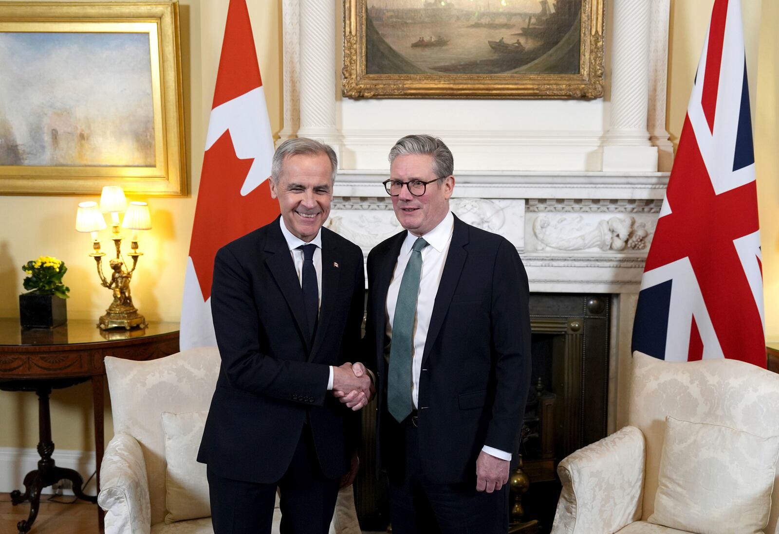 Britain's Prime Minister Sir Keir Starmer, right, and Canada's Prime Minister Mark Carney, left, shake hands during a meeting in 10 Downing Street, London, England, Monday March 17, 2025. (Jordan Pettitt/PA via AP, Pool)