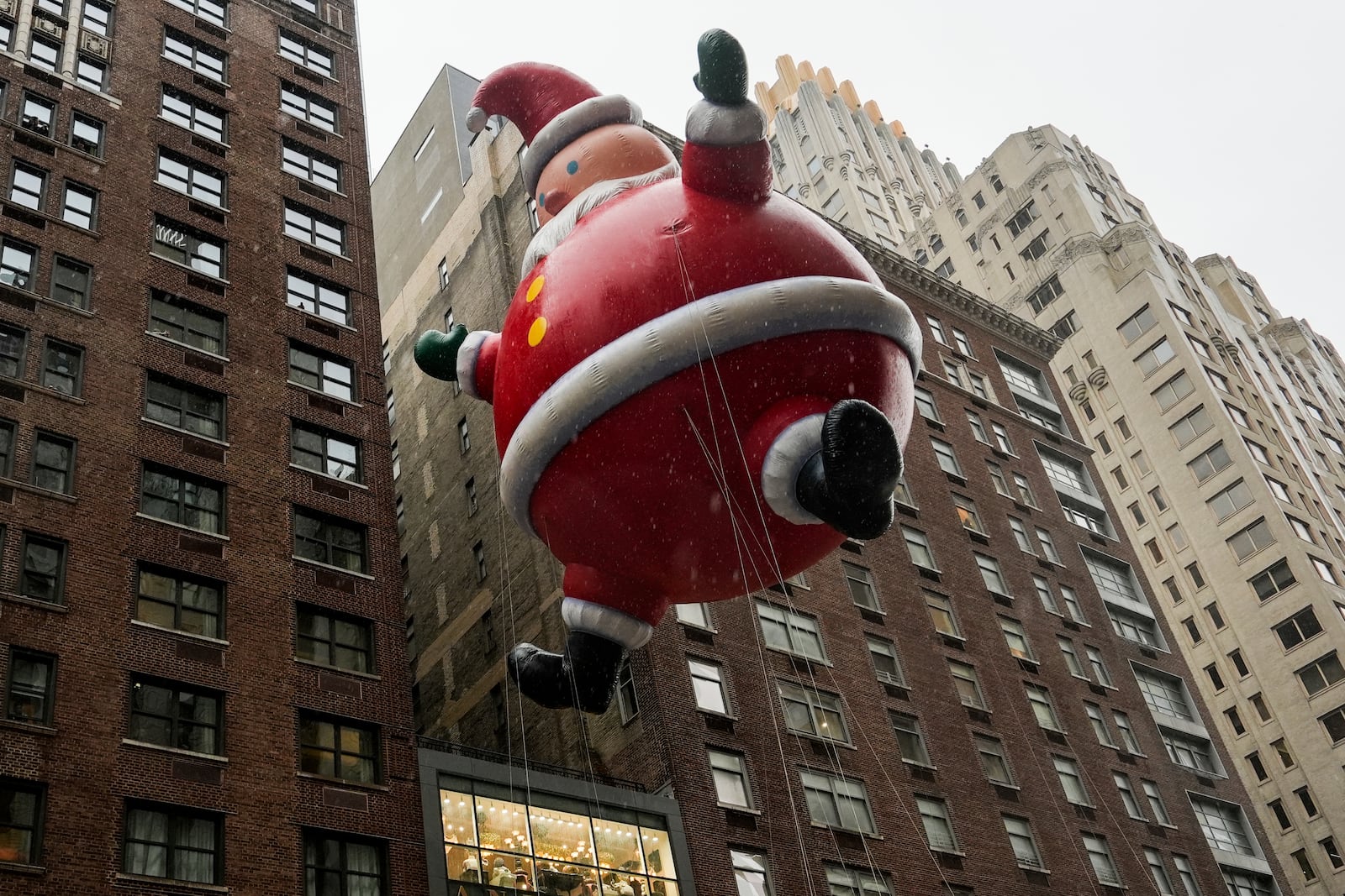 Handlers guide a Santa Claus balloon down Sixth Avenue during the Macy's Thanksgiving Day Parade, Thursday, Nov. 28, 2024, in New York. (AP Photo/Julia Demaree Nikhinson)