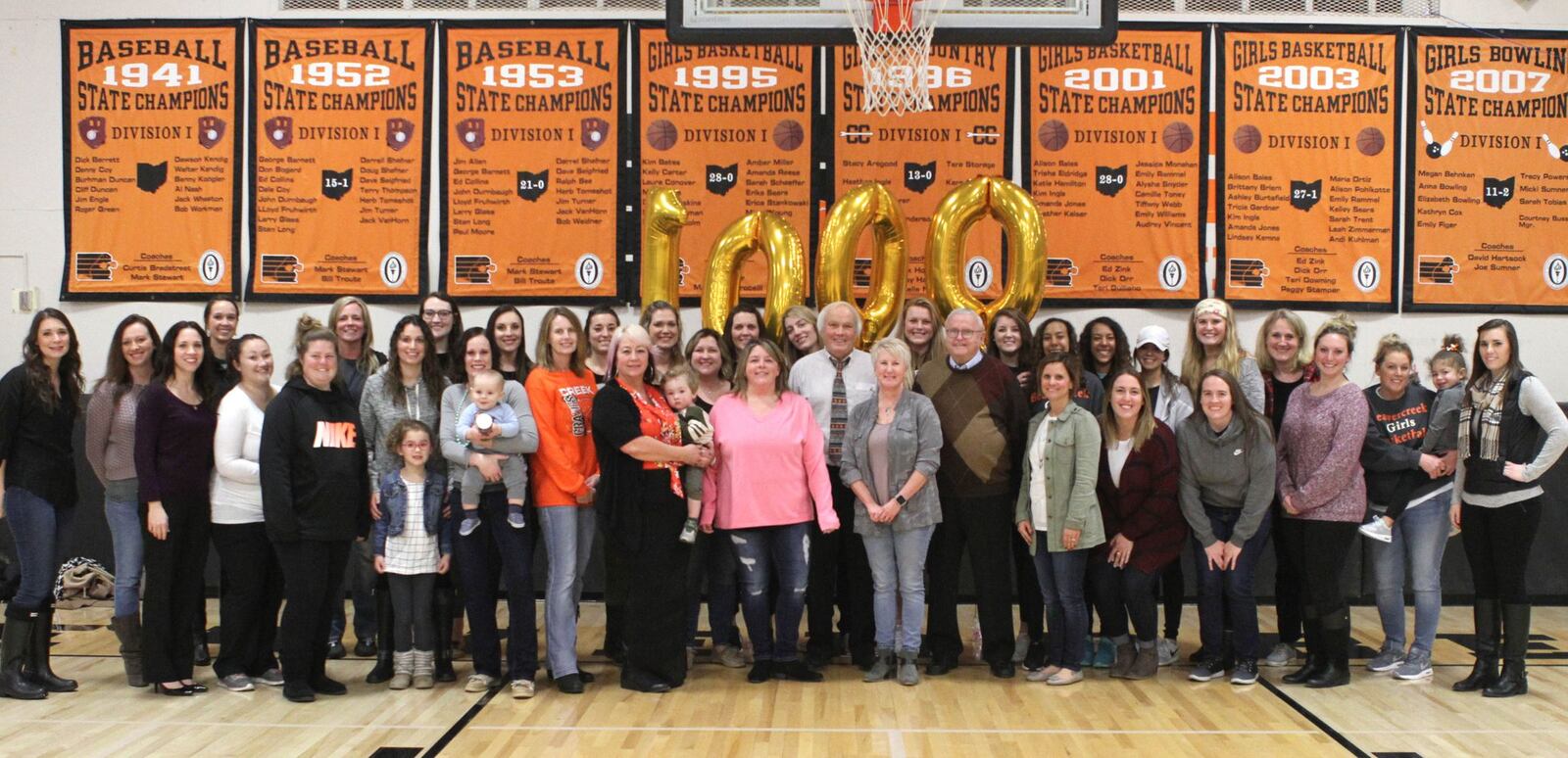 Former Beavercreek High School girls basketball members huddle with coach Ed Zink (center) after he coached his 1,000th game. Beavercreek defeated visiting Northmont 65-38 on Wed., Jan. 10, 2018. RANDY WIMER / CONTRIBUTED