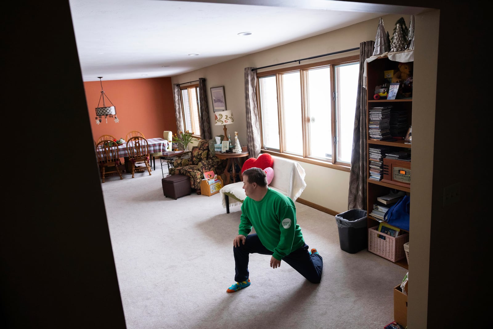 Paul Safarik, 32, stretches while listening to music in his home on Wednesday, Feb. 12, 2025, in Lincoln, Neb. (AP Photo/Rebecca S. Gratz)