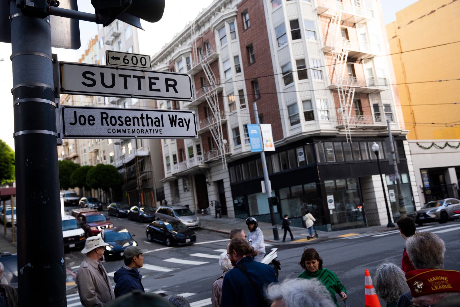 People gather by the street sign Joe Rosenthal Way, that honors the former AP photojournalist who the Pulitzer Prize for his iconic photo of U.S. Marines raising the flag on the Japanese island of Iwo Jima during WWII, Thursday, Dec. 12, 2024, in San Francisco. (AP Photo/Minh Connors)