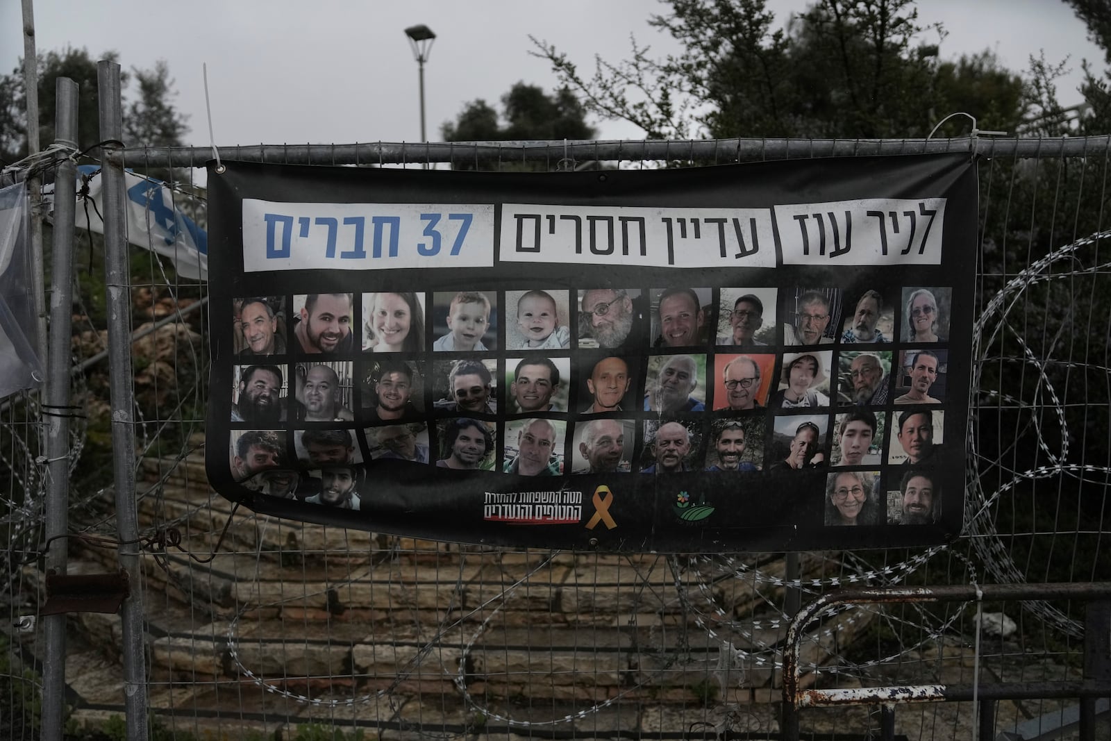 A poster shows portraits of Bibas family, top row from second left: Yarden, Shiri, and their sons Ariel and Kfir, who were kidnapped to Gaza on Oct. 7, 2023, in Jerusalem, Friday, Feb. 21, 2025. (AP Photo/Mahmoud Illean)