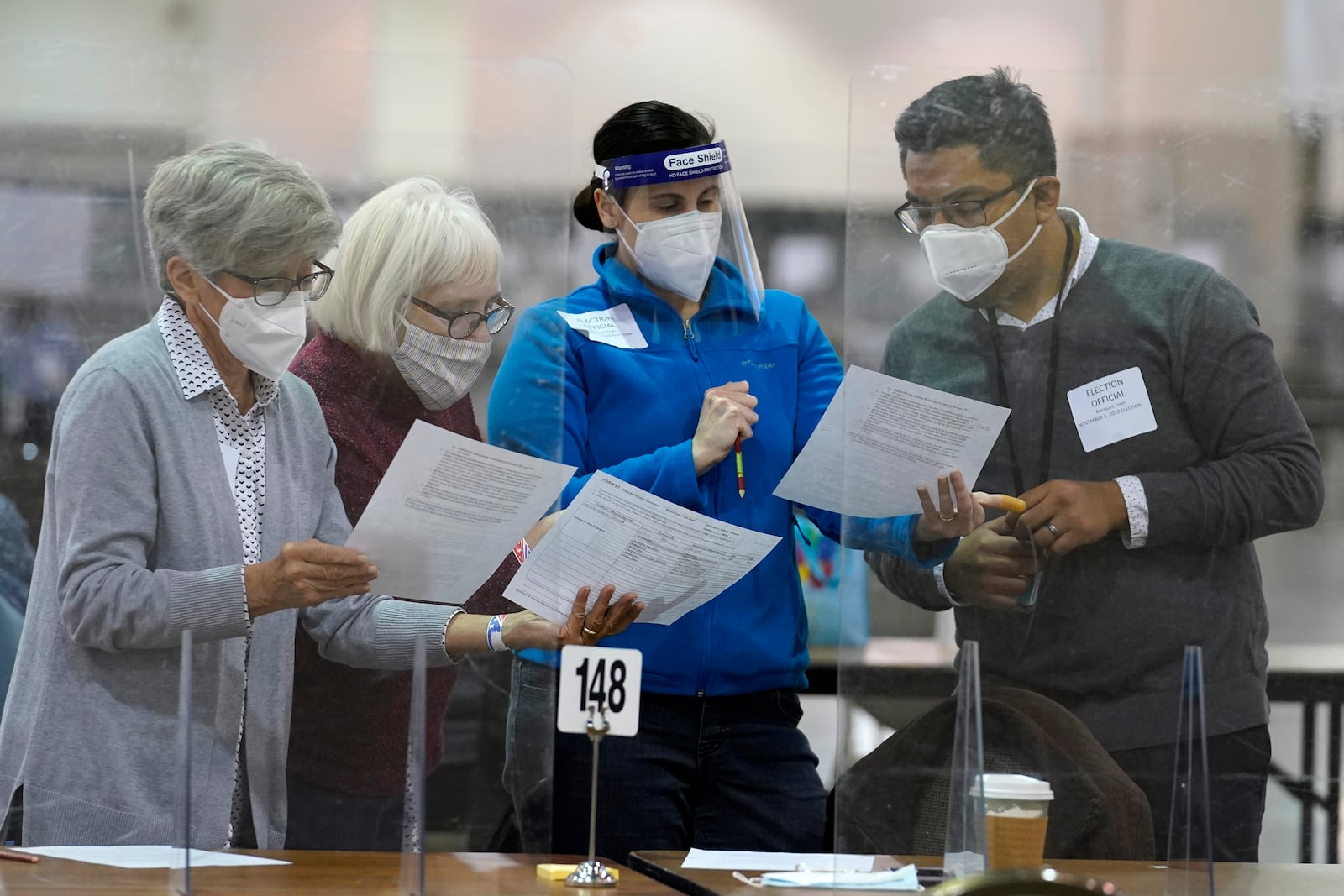 FILE - Election officials read documents before a hand recount of ballots at the Wisconsin Center, Friday, Nov. 20, 2020, in Milwaukee, Wis. (AP Photo/Nam Y. Huh, File)