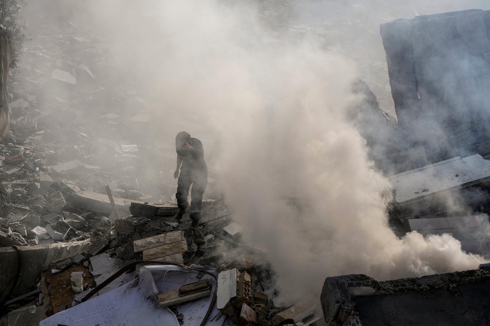 A civil defense worker checks a building that collapsed after it was hit in an Israeli airstrike in Hadath, south of Beirut, Lebanon, Sunday, Nov. 17, 2024. (AP Photo/Bilal Hussein)