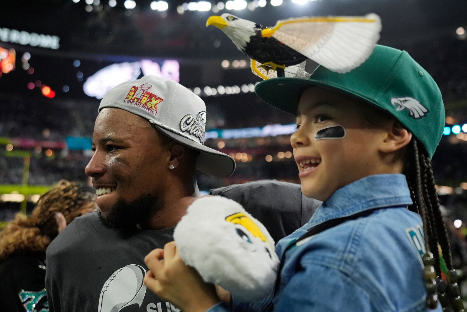 Philadelphia Eagles running back Saquon Barkley holds his daughter Jada after the NFL Super Bowl 59 football game against the Kansas City Chiefs, Sunday, Feb. 9, 2025, in New Orleans. (AP Photo/Frank Franklin II)