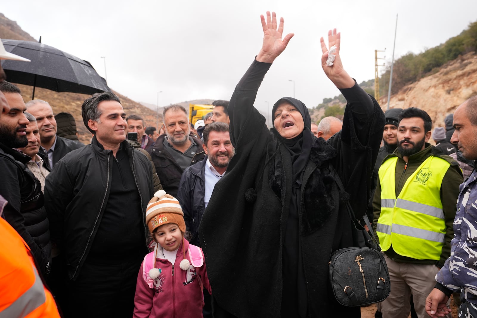 Caretaker Transportation Minister Ali Hamieh, left, welcomes displaced residents returning from Syria at the Masnaa border crossing, eastern Lebanon, following a ceasefire between Israel and Hezbollah on Wednesday, Nov. 27, 2024. (AP Photo/Hassan Ammar)