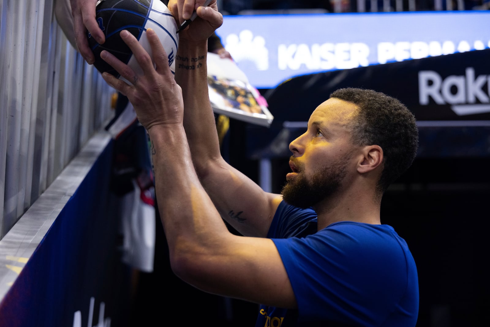 Golden State Warriors guard Stephen Curry gives autographs to fans before an NBA basketball game against the Dallas Mavericks, Sunday, Dec. 15, 2024, in San Francisco. (AP Photo/Benjamin Fanjoy)