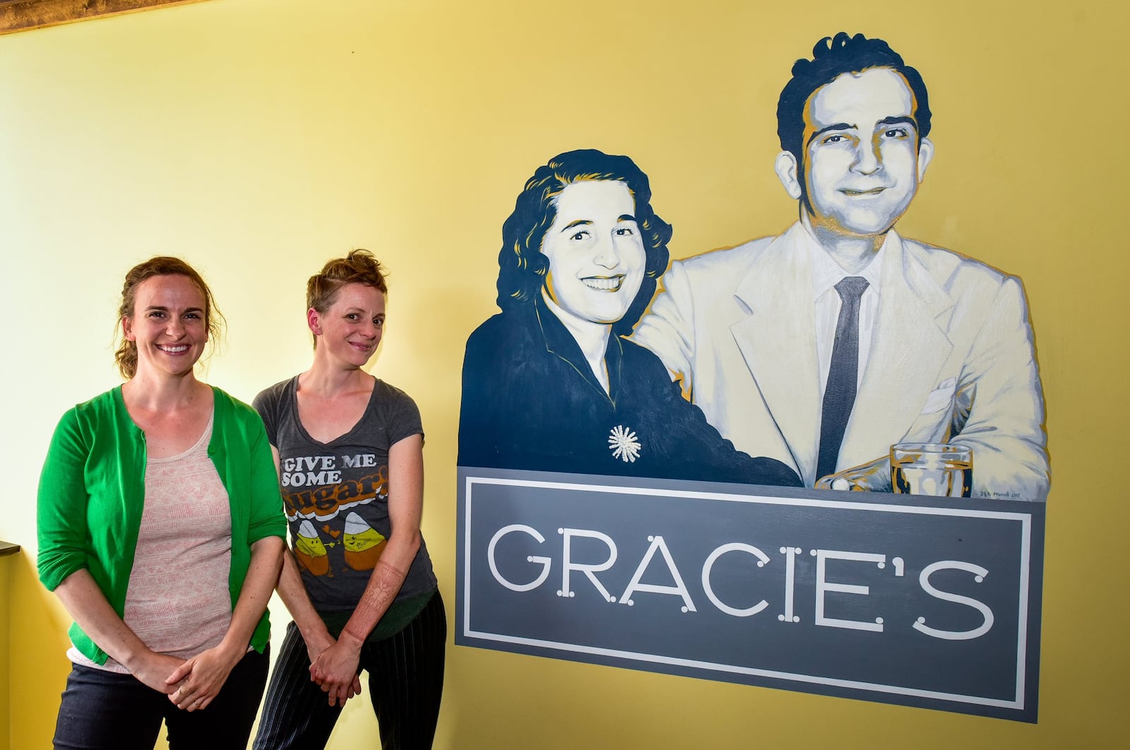 Sisters Audrey Morrell (left) and Jennifer Morrell stand by one of their paintings inside Gracie’s restaurant on Central Avenue in Middletown. 