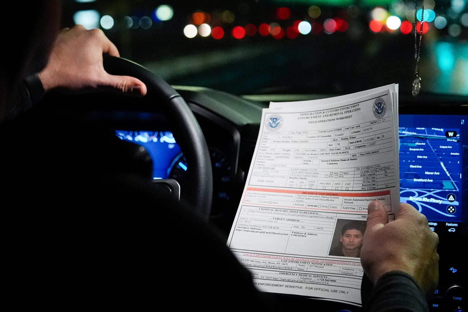 Kenneth Genalo, director of U.S. Immigration and Customs Enforcement's New York City field office, holds an information sheet on Wilmer Patricio Medina-Medina during an early morning operation, Tuesday, Dec. 17, 2024, in the Bronx borough of New York. (AP Photo/Julia Demaree Nikhinson)