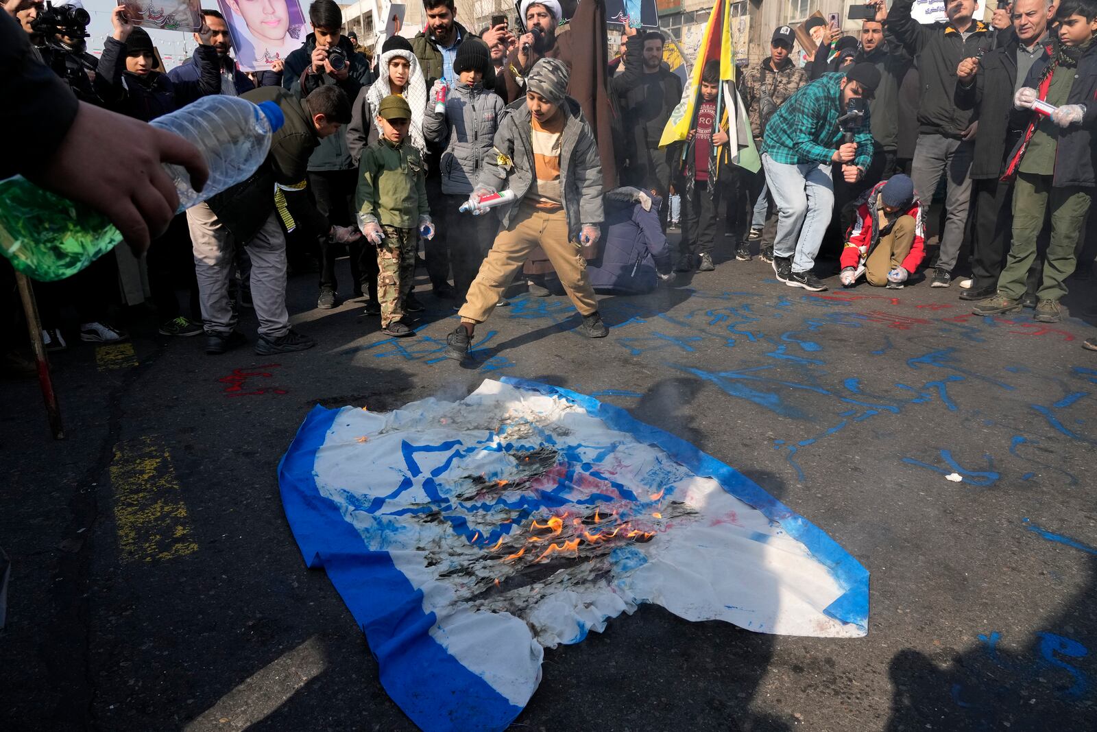 Iranian demonstrators burn a representation of the Israeli flag during a rally commemorating anniversary of Iran's 1979 Islamic Revolution that toppled the late pro-U.S. Shah Mohammad Reza Pahlavi and brought Islamic clerics to power, in Tehran, Iran, Monday, Feb. 10, 2025. (AP Photo/Vahid Salemi)