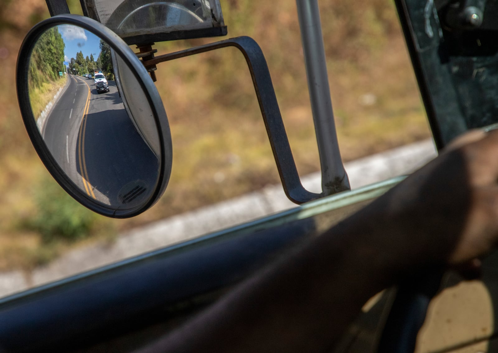 FILE - Trucks loaded with avocados are seen reflected on a rear view mirror as they are escorted by the police on their way to the city of Uruapan, in Santa Ana Zirosto, Michoacan state, Mexico, Jan. 26, 2023. (AP Photo/Armando Solis, File)