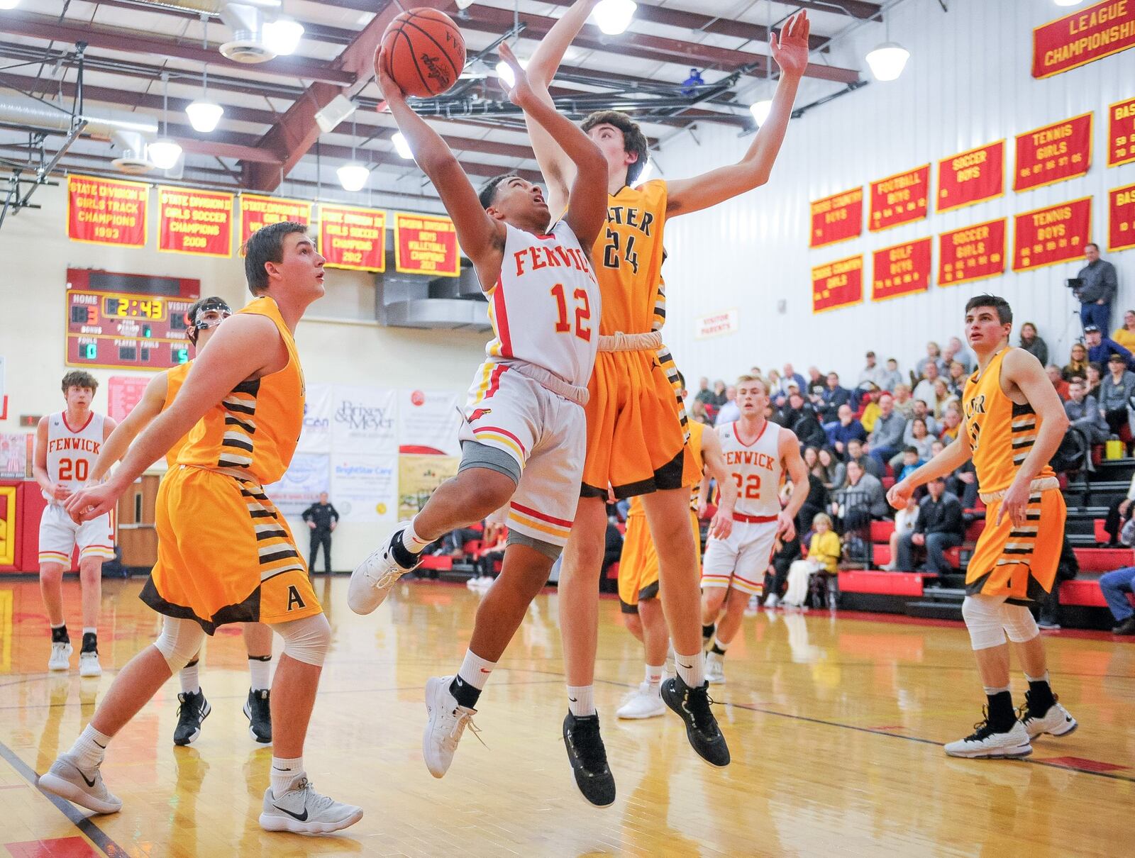 Fenwick’s Jordan Rucker goes to the basket defended by Alter’s Conor Stolly (24) during Friday night’s game in Middletown. Alter won 56-38. NICK GRAHAM/STAFF