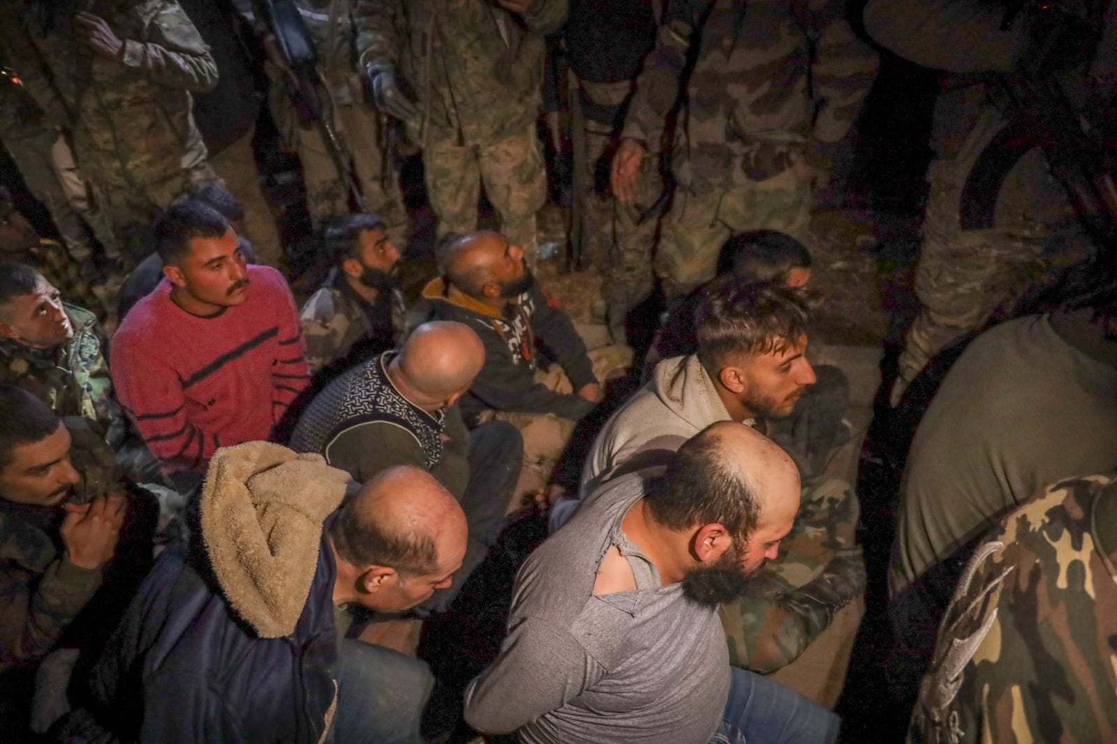 Alleged Syrian army soldiers and allied fighters sit on the floor after being captured by opposition fighters in Aleppo, Syria, Saturday Nov. 30, 2024. Thousands of Syrian insurgents have fanned out inside Syria's largest city Aleppo a day after storming it with little resistance from government troops.(AP Photo/Omar Albam)