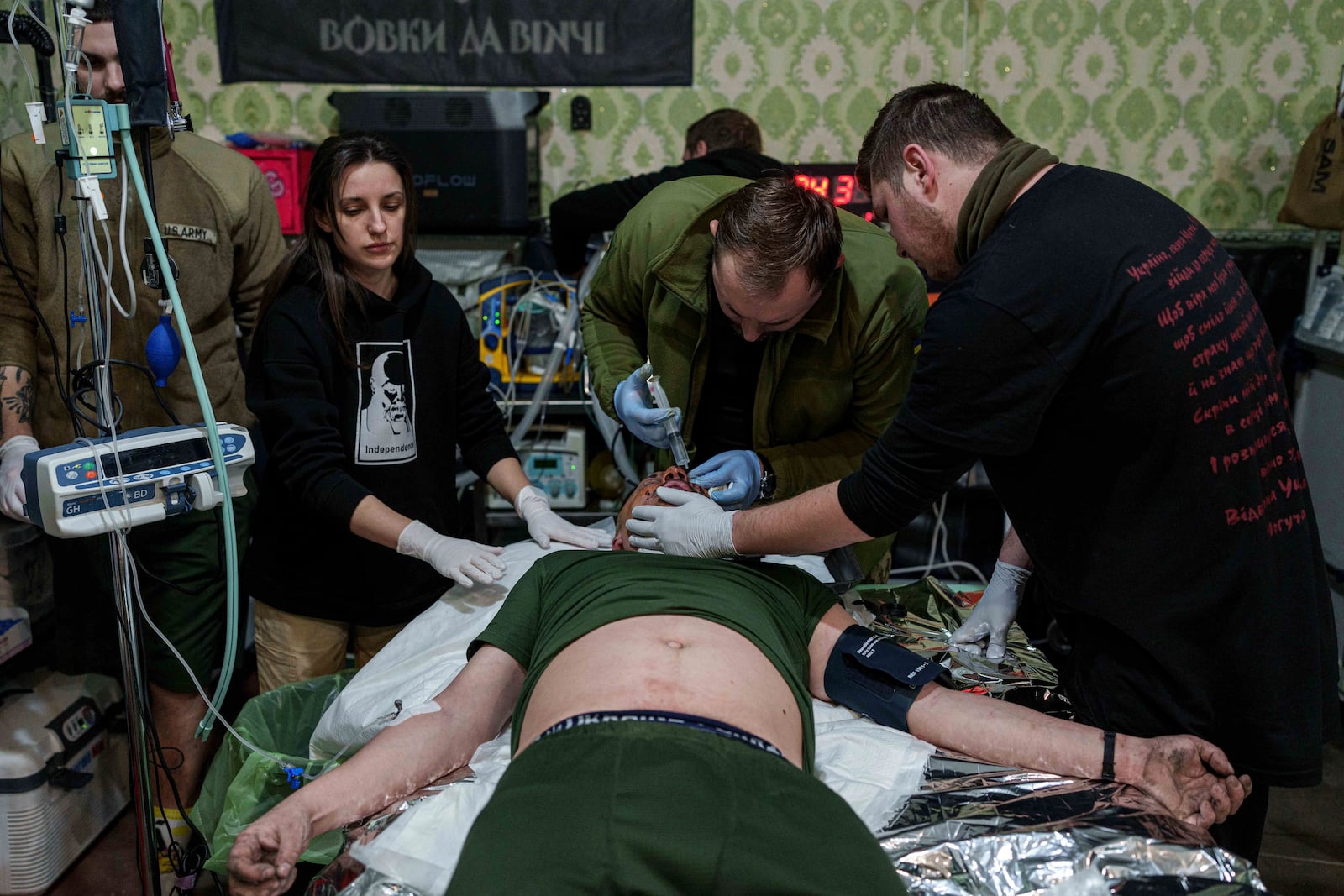 A medic treats an injured Ukrainian serviceman at Medical Service "Ulf" of the 108th Separate Battalion "Da Vinci Wolves" on Pokrovsk direction, Ukraine, Monday, Dec. 23, 2024. (AP Photo/Evgeniy Maloletka)