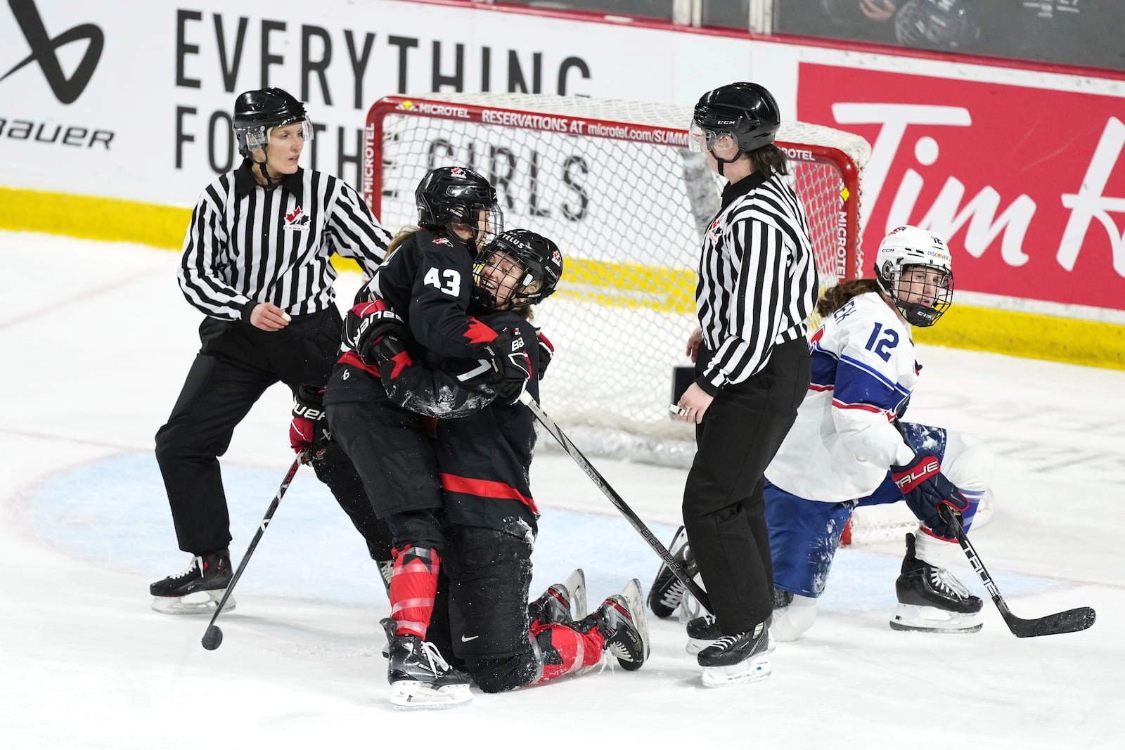 Canada's Laura Stacey (7) celebrates after her empty-net goal with teammate Kristin O'Neill (43) near United States' Kelly Pannek (12) during the third period of a Rivalry Series hockey game in Summerside, Prince Edward Island, Canada, Saturday, Feb. 8, 2025. (Darren Calabrese/The Canadian Press via AP)