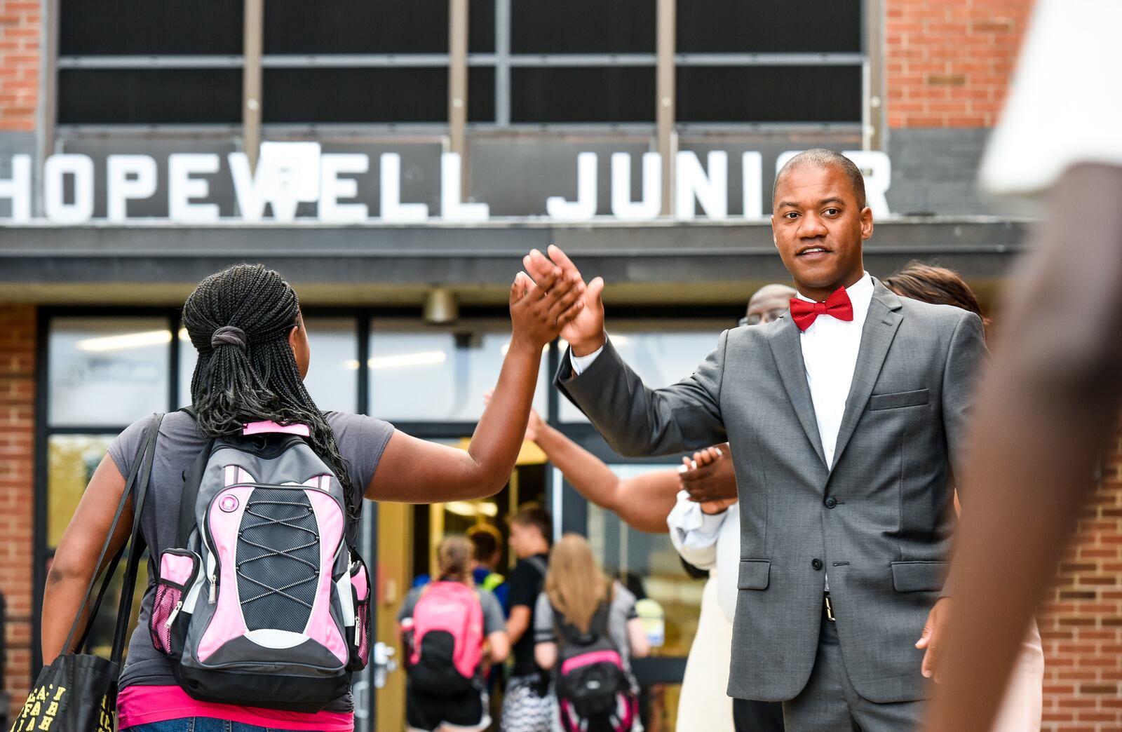 Marlon Styles, as Executive Director of Curriculum & Instruction at Lakota Local Schools, gives students high-fives as Hopewell Junior students return from summer break in 2016. 