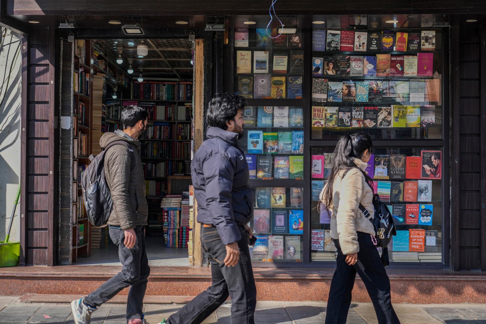 People walk outside a book shop in Srinagar, Indian controlled Kashmir, Monday, Feb. 17, 2025.(AP Photo/Mukhtar Khan)