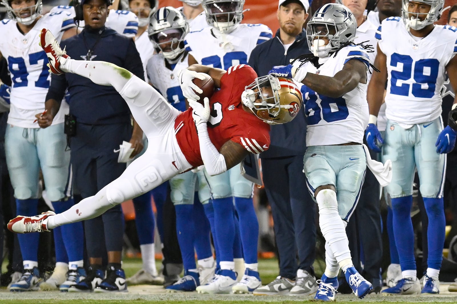 San Francisco 49ers cornerback Deommodore Lenoir, foreground left, intercepts a pass intended for Dallas Cowboys wide receiver CeeDee Lamb (88) during the second half of an NFL football game in Santa Clara, Calif., Sunday, Oct. 27, 2024. (AP Photo/Eakin Howard)