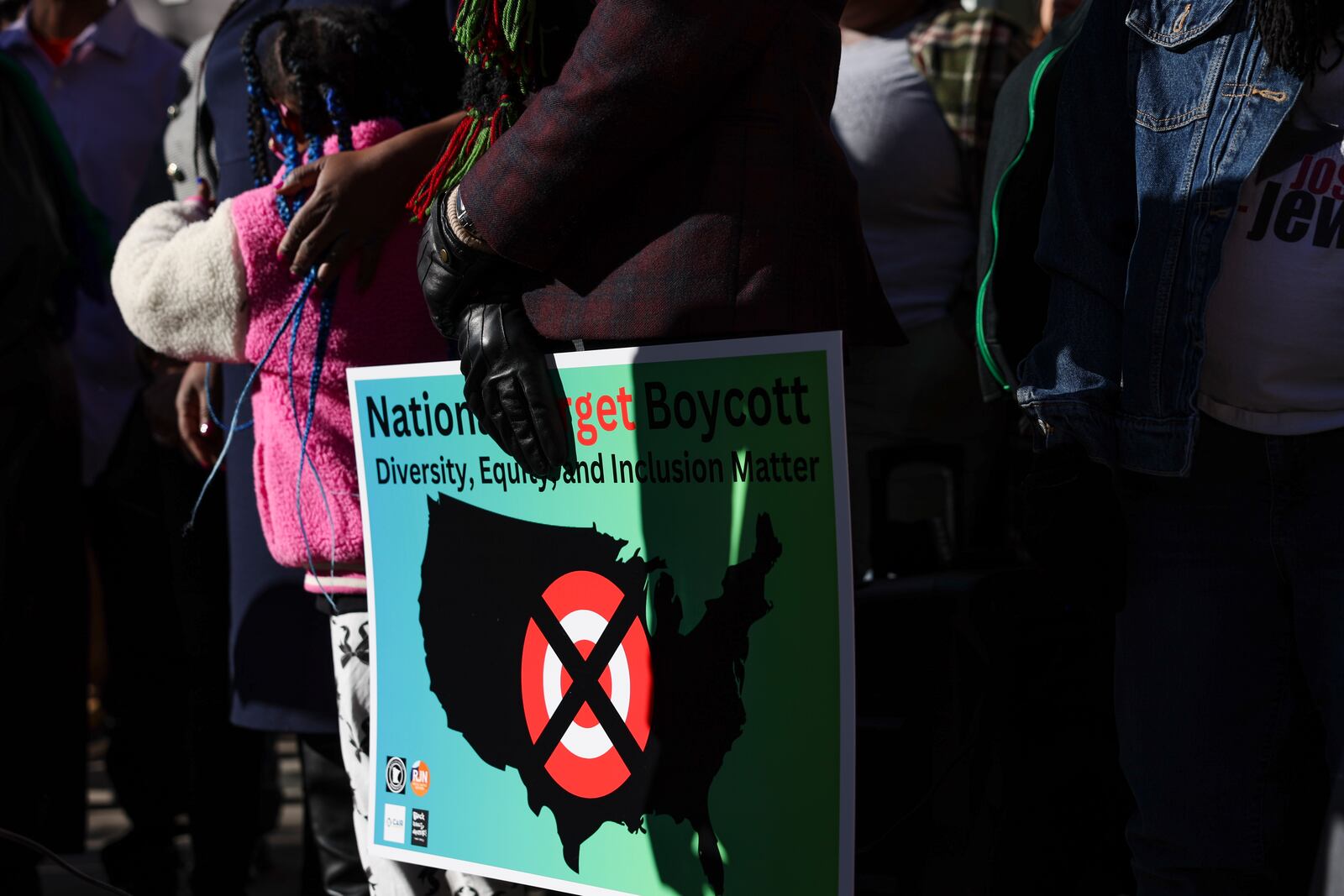 A community member holds a sign calling for a national boycott of Target stores during a news conference outside Target Corporation's headquarters Thursday, Jan. 30, 2025, in Minneapolis, Minn. (AP Photo/Ellen Schmidt)