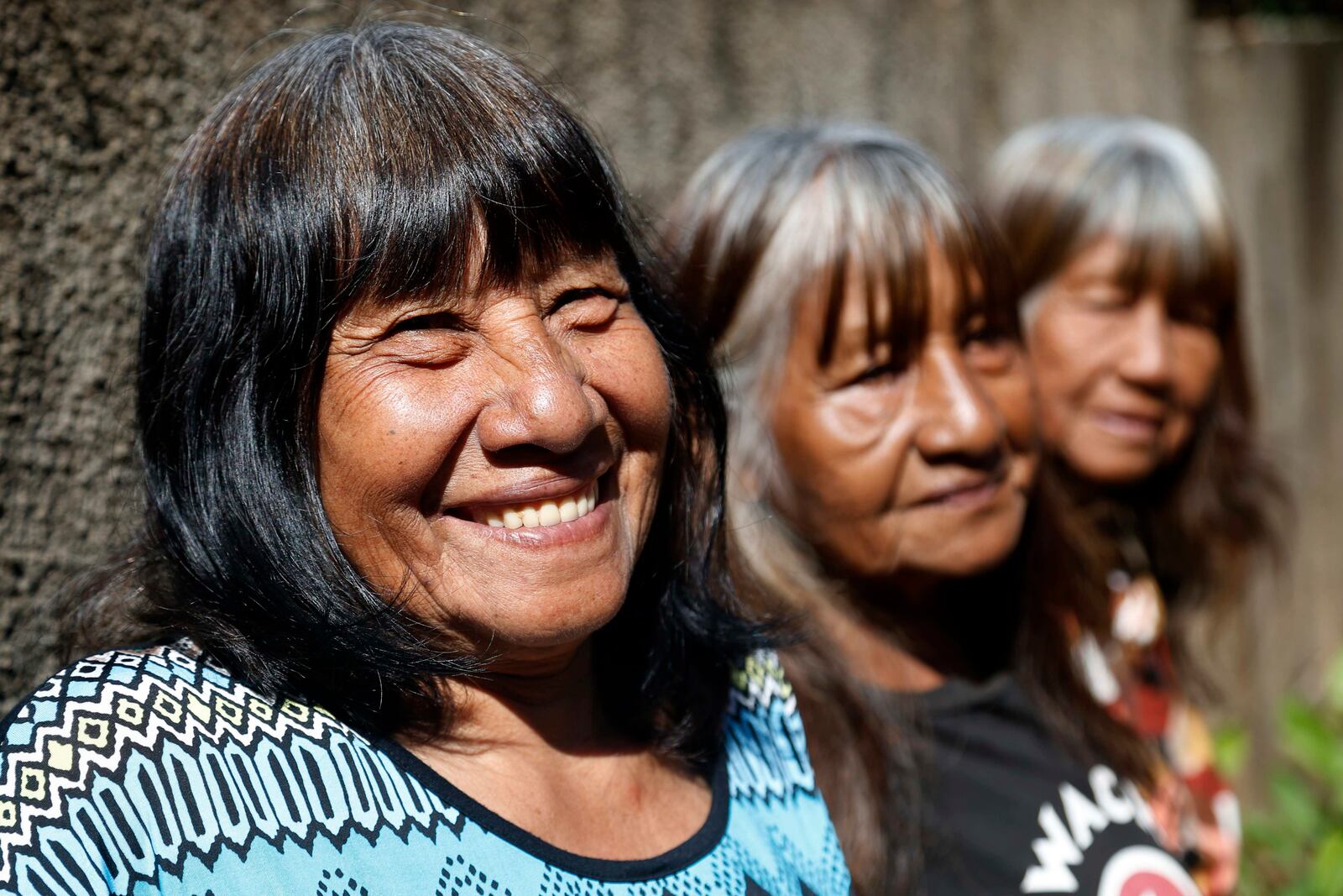 FILE - Maka indigenous leader-in-training Tsiweyenki, whose Spanish name is Gloria Elizeche, smiles with her sisters Cristina, center, and Estela as they cook in her backyard in Mariano Roque Alonso, Paraguay, April 29, 2019. (AP Photo/Jorge Saenz, File)