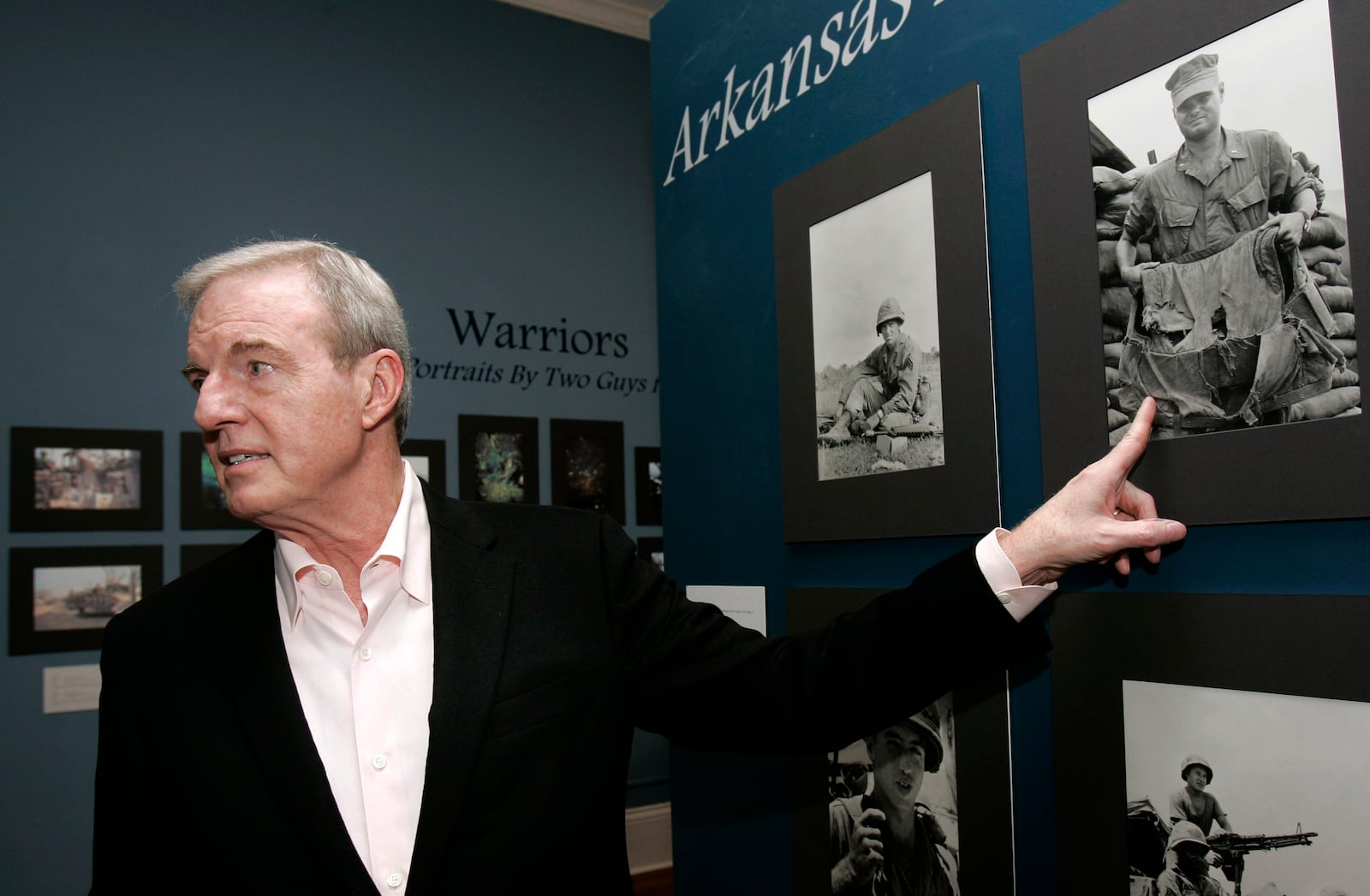 FILE - Former Arkansas Gov. Jim Guy Tucker talks about photographs on display made while serving as a U.S. Marine Corps war correspondent in 1965 and 1967, at the MacArthur Museum of Arkansas Military History in Little Rock, Ark., in Vietnam, March 4, 2010. (AP Photo/Danny Johnston, File)