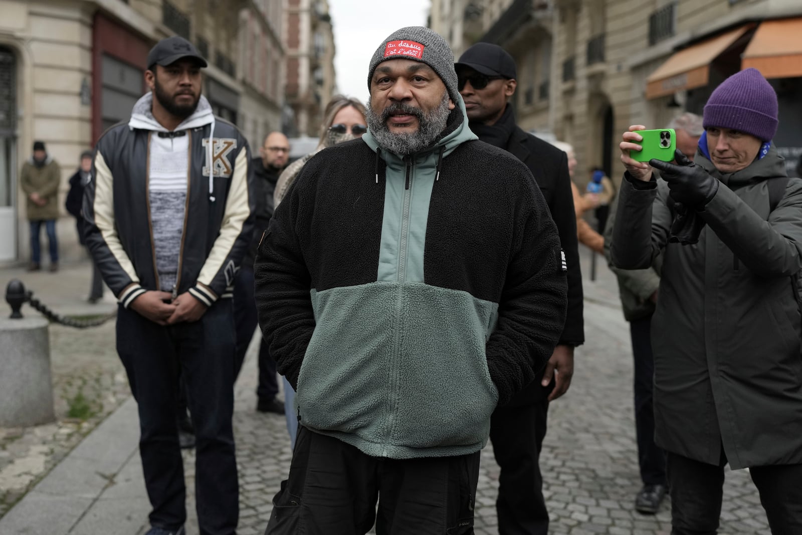 Dieudonne M'Bala M'Bala, a French comedian repeatedly convicted of inciting antisemitism or racial hatred, stays outside Notre Dame du Val-de-Grace church during a public memorial for late far-right leader Jean-Marie Le Pen, Thursday, Jan. 16, 2025 in Paris. Jean-Marie Le Pen, the founder of France's main far-right party, died on Jan.7, 2025 aged 96. (AP Photo/Thibault Camus)