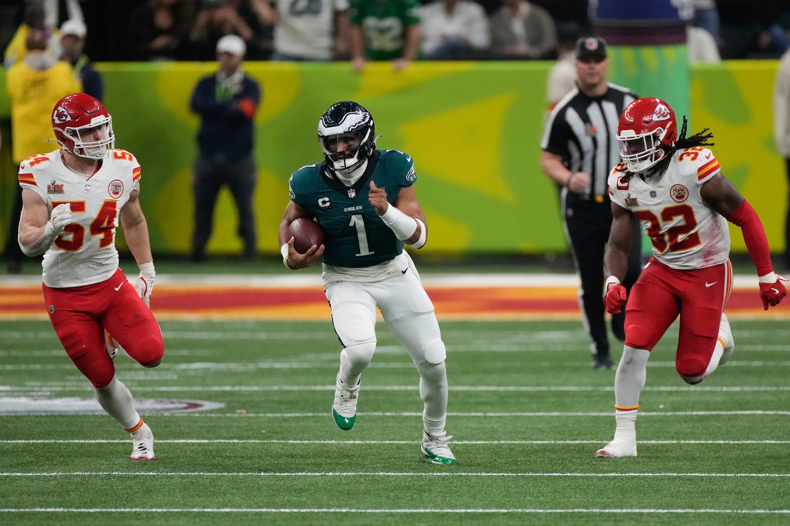 Philadelphia Eagles quarterback Jalen Hurts (1) runs past Kansas City Chiefs linebacker Leo Chenal (54) and linebacker Nick Bolton (32) during the second half of the NFL Super Bowl 59 football game, Sunday, Feb. 9, 2025, in New Orleans. (AP Photo/Stephanie Scarbrough)