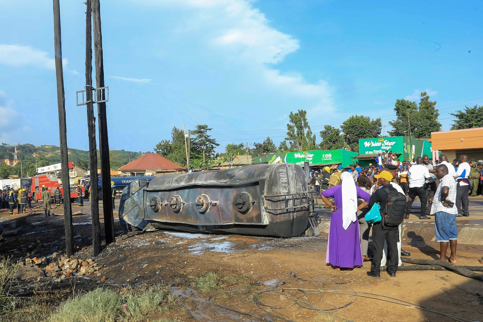 People gather near the site where a fuel truck exploded, next to a highway on the outskirts of Kampala, Uganda, Tuesday, Oct. 22, 2024. (AP Photo)