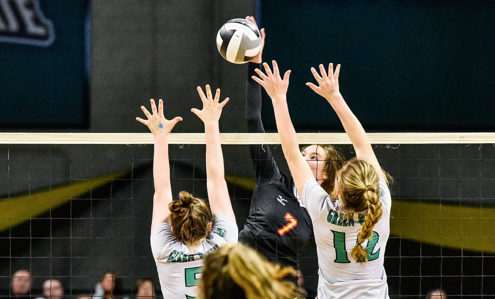 Fenwick’s Elizabeth Hoerlein goes up and over Parma Heights Holy Name’s Ava Nice (5) and Kayla Jarosz (12) during Friday’s Division II state volleyball semifinal at Wright State University’s Nutter Center. NICK GRAHAM/STAFF