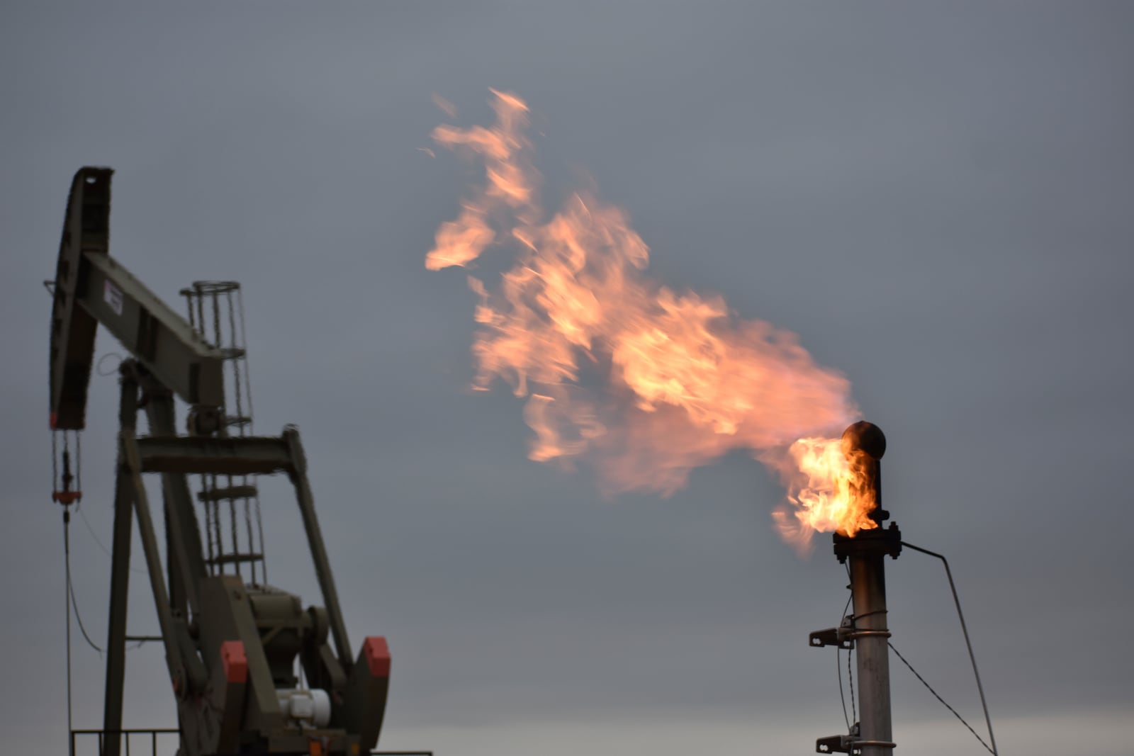 FILE - A flare for burning excess methane, or natural gas, from crude oil production is seen at a well pad in Watford City, N.D., Aug. 26, 2021. (AP Photo/Matthew Brown, File)